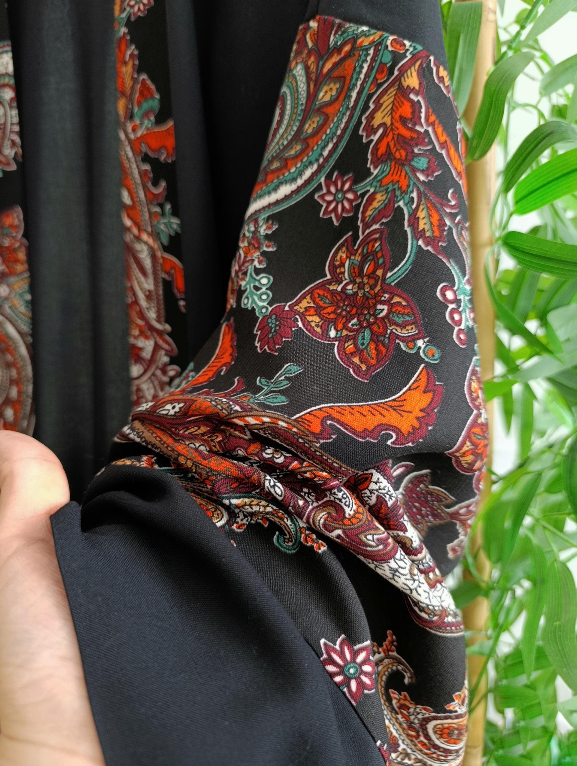 Short black kimono robe with vibrant paisley-patterned sleeves and matching belt