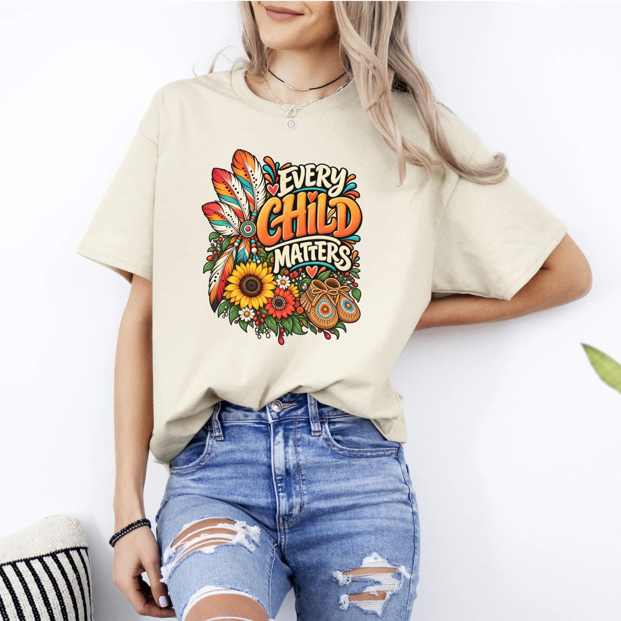 T-shirt with "Every Child Matters" text, feathers, sunflowers, flowers, and moccasins.