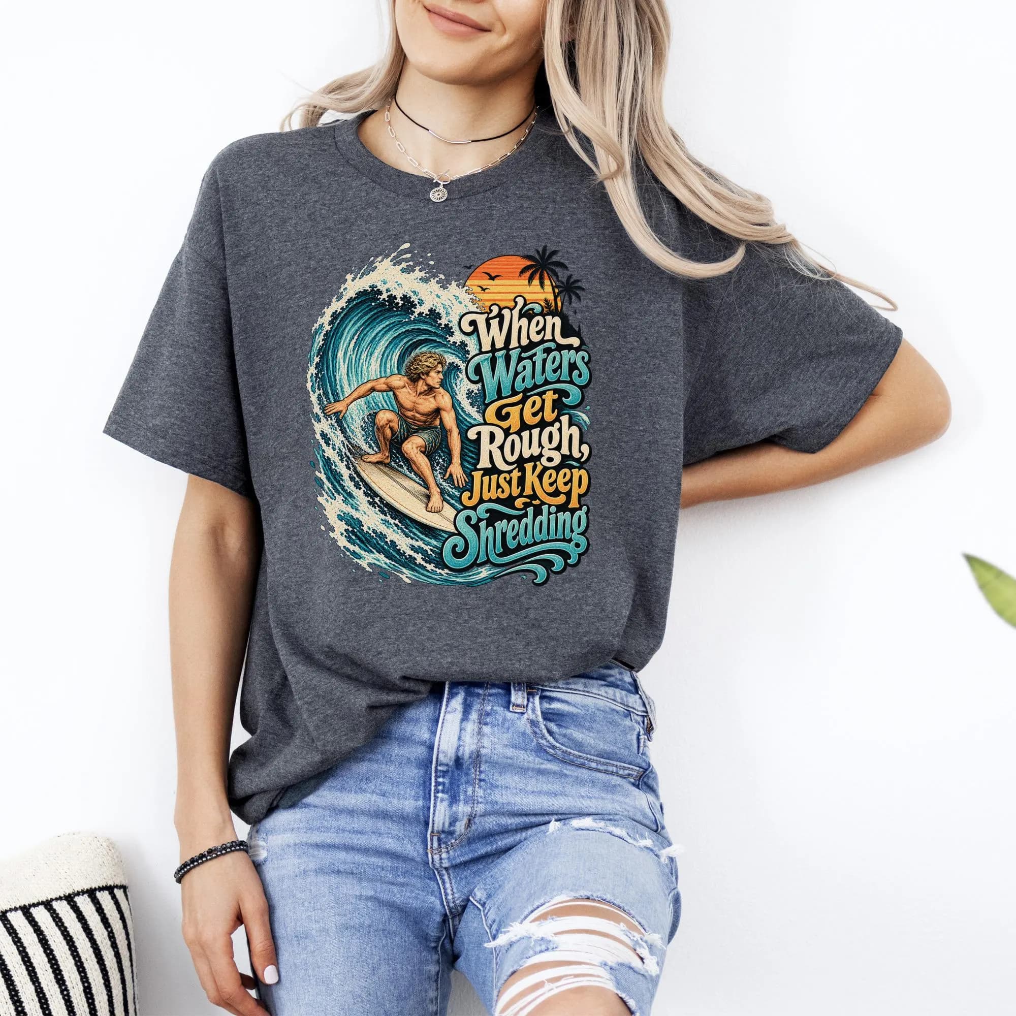 Dark grey t-shirt with "When Waters Get Rough, Just Keep Shredding" surfing graphic.