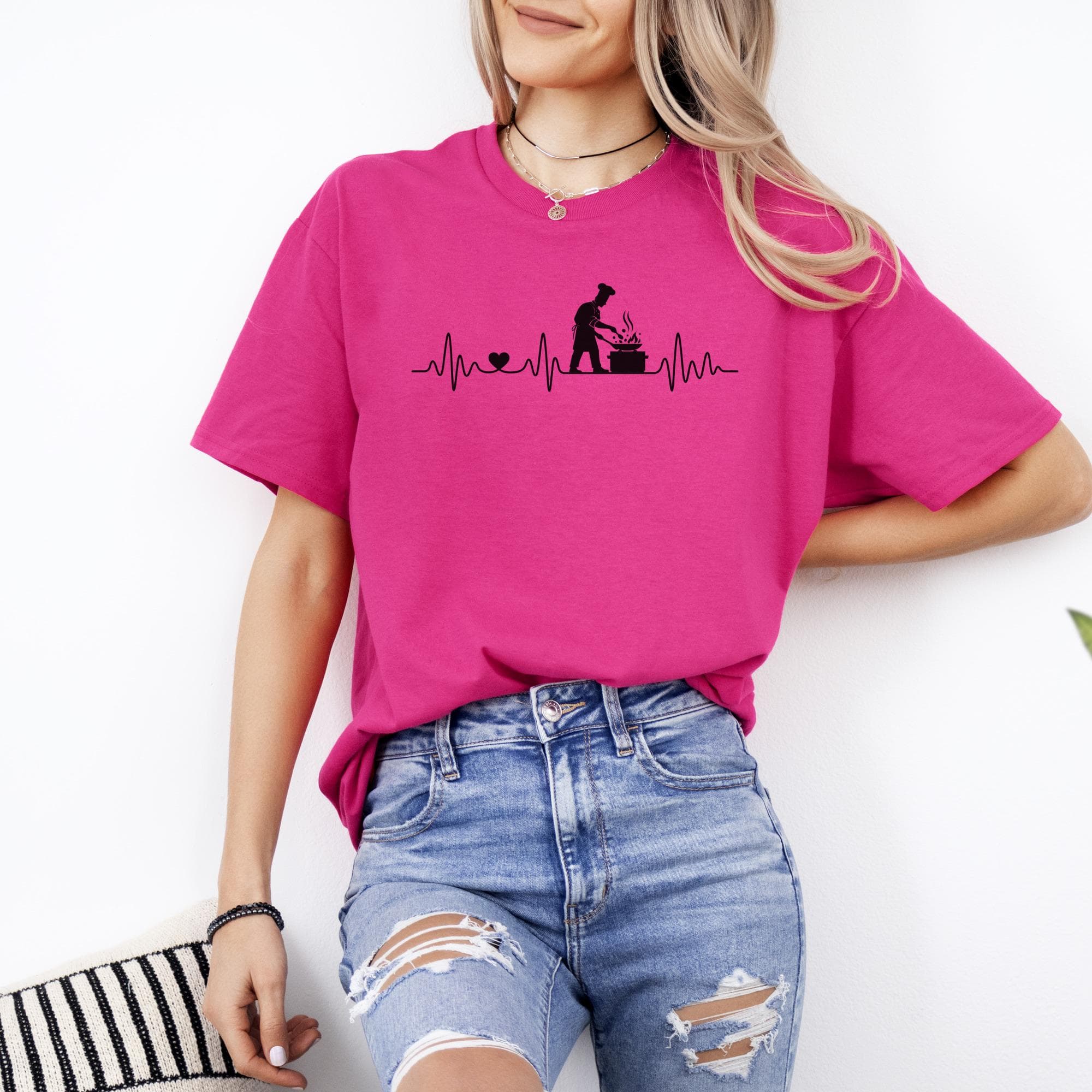 Pink t-shirt with a black graphic of a heartbeat, heart, and chef cooking.