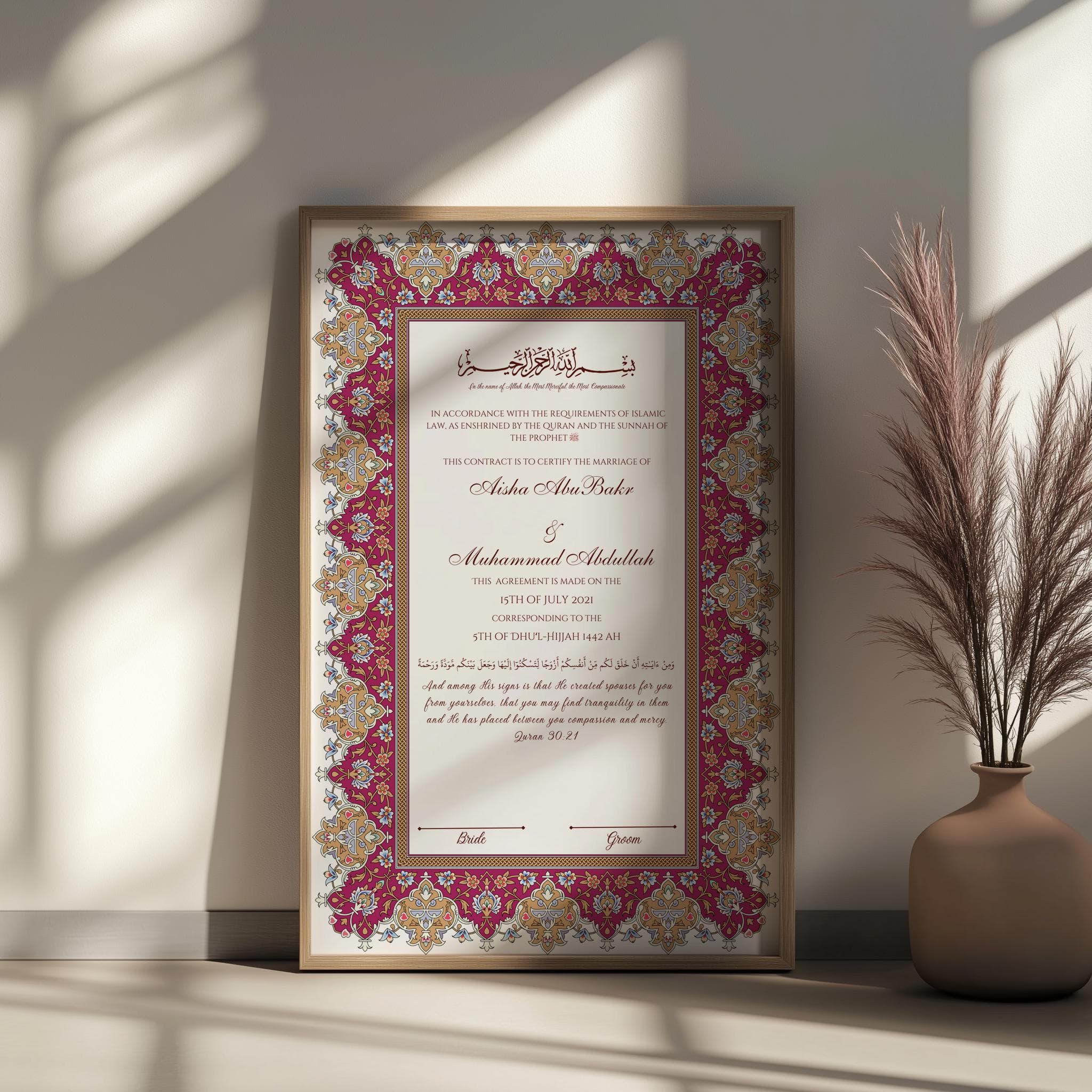 May include: Framed marriage certificate with ornate burgundy and gold border. The document features Arabic calligraphy and English text, including names and a date. A decorative vase with tall grass is in the background.