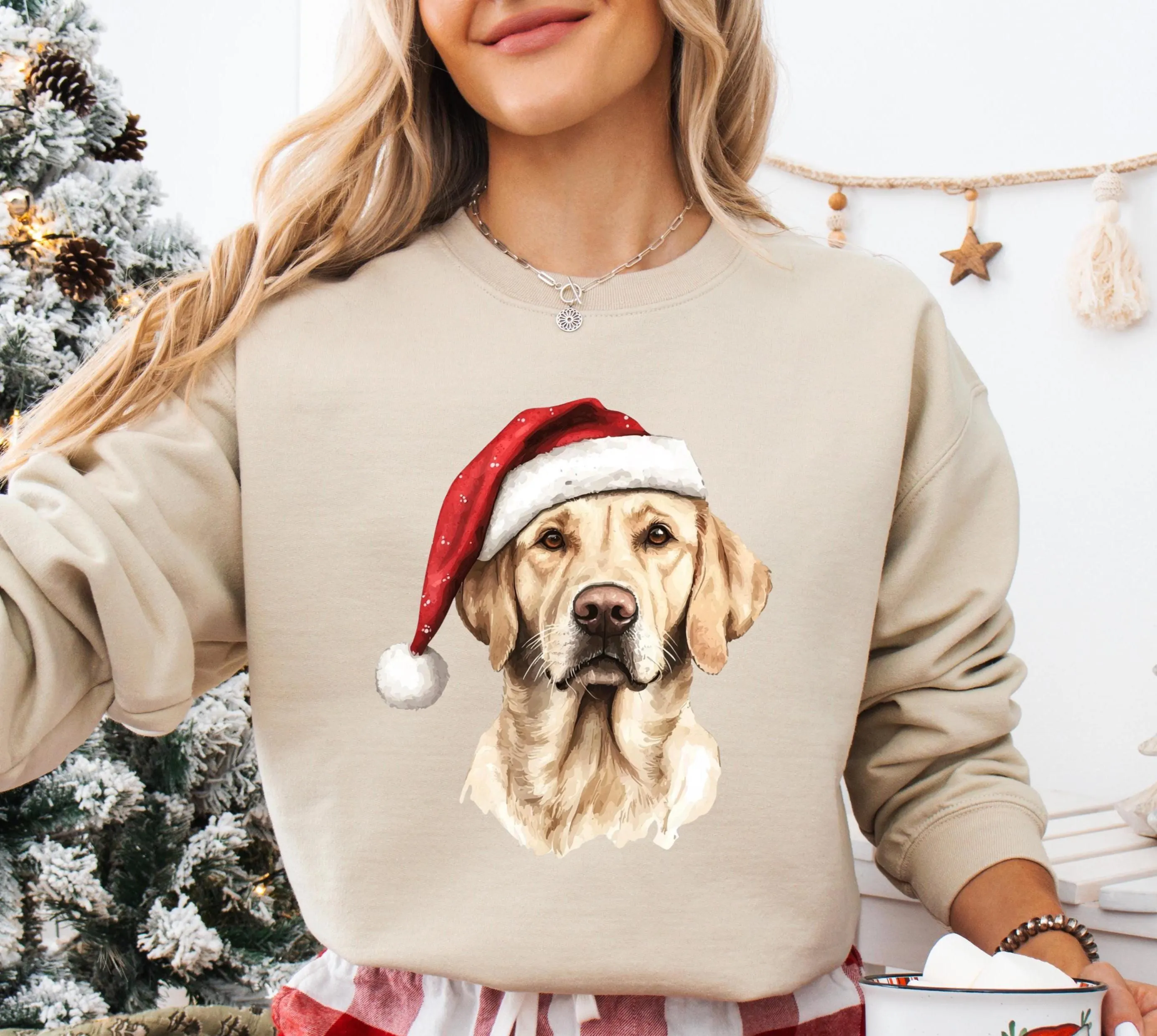 A woman wearing a beige sweater with a Christmas-themed dog wearing a Santa hat.