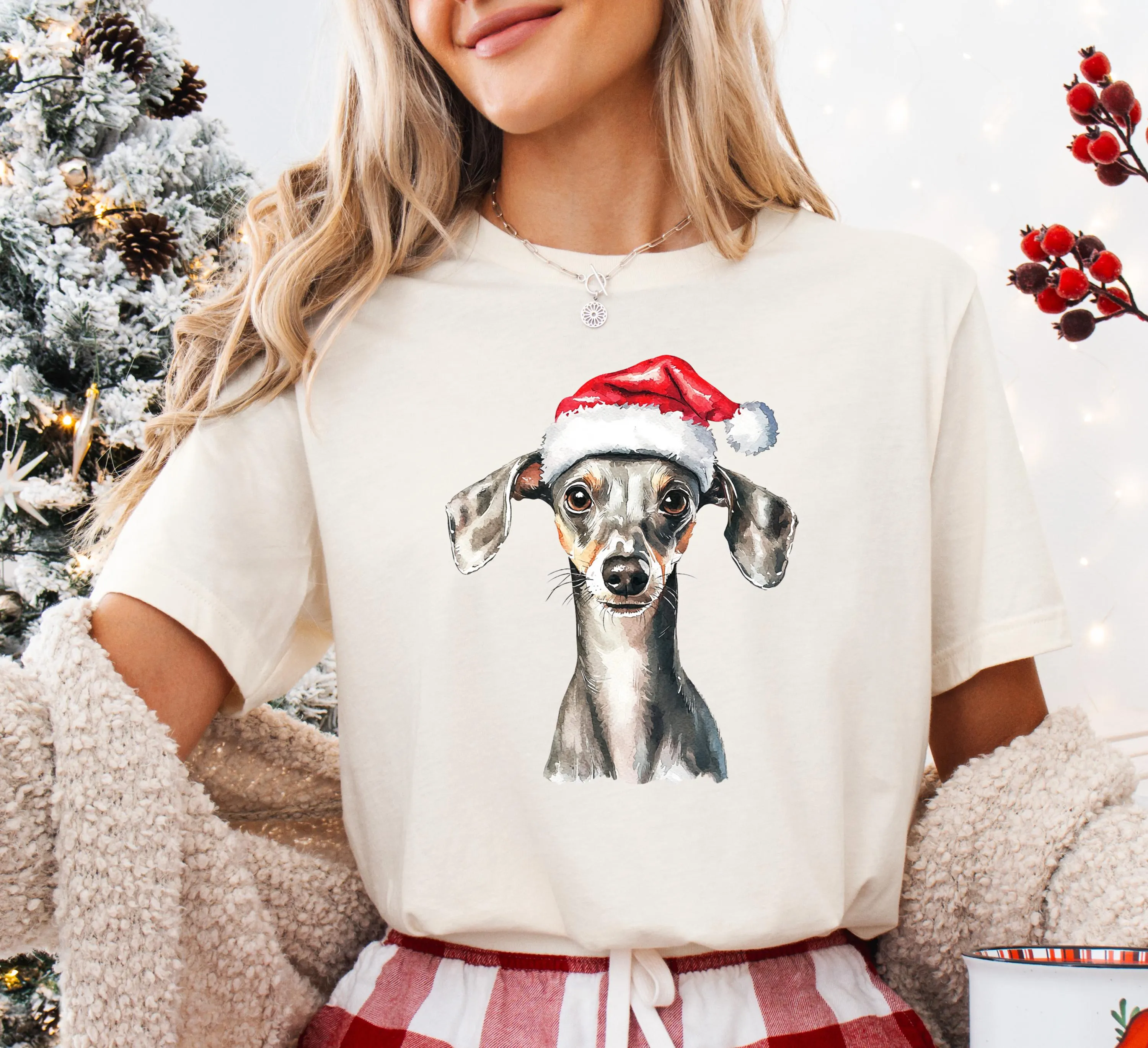 A woman wearing a white t-shirt with a picture of a dog wearing a Santa hat.