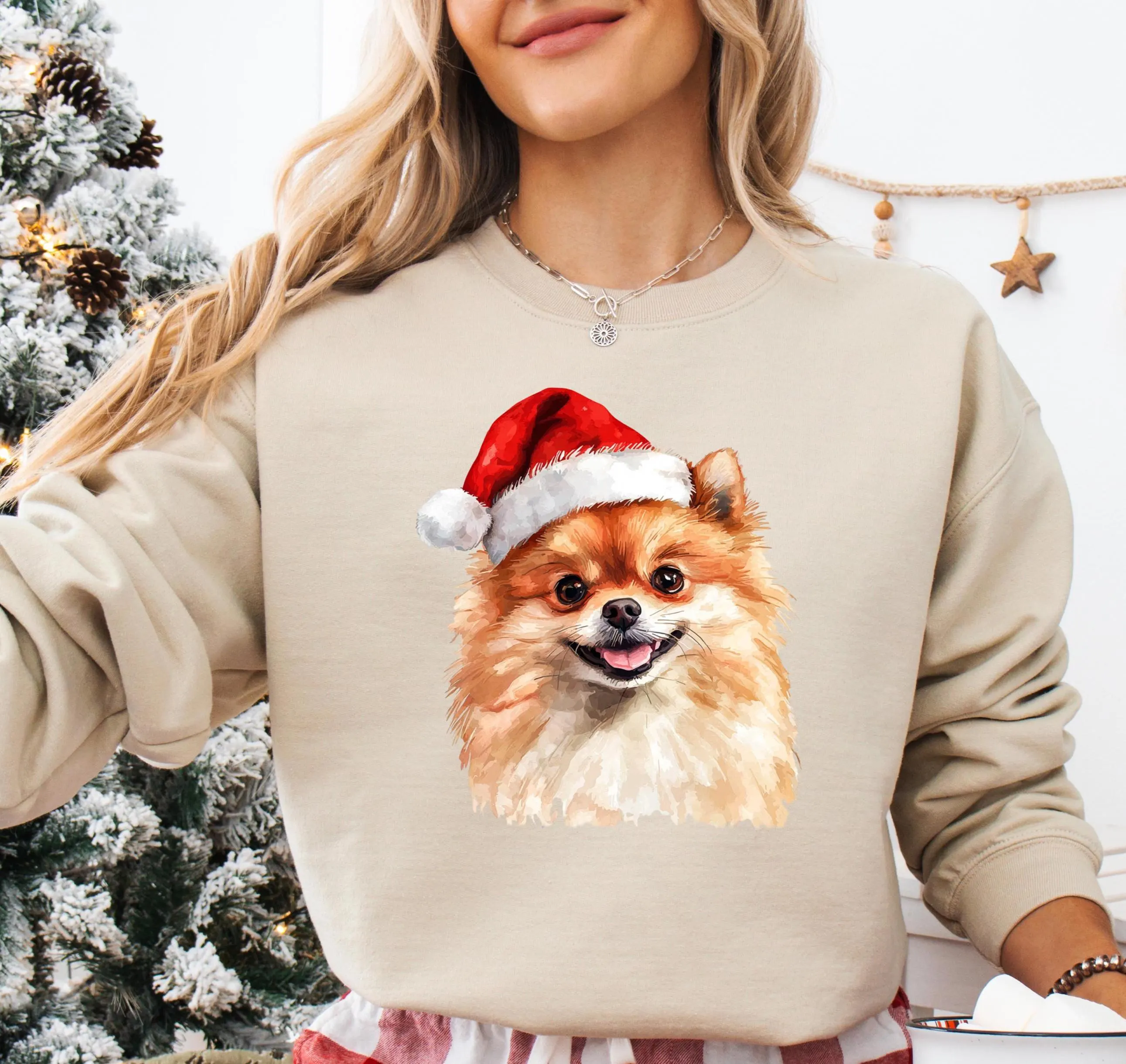 A woman wearing a beige sweater with a printed image of a Pomeranian dog wearing a Santa hat.