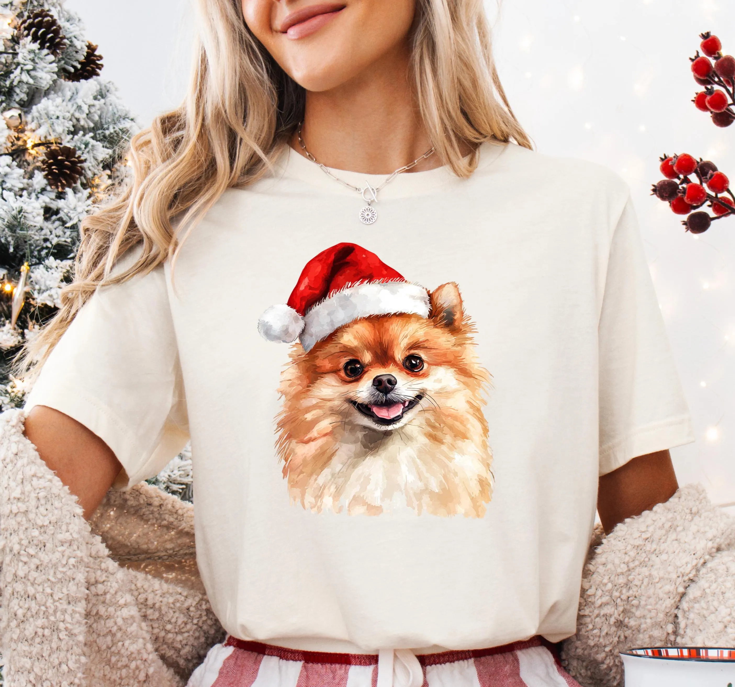 A woman wearing a white t-shirt with a picture of a Pomeranian dog wearing a Santa hat.