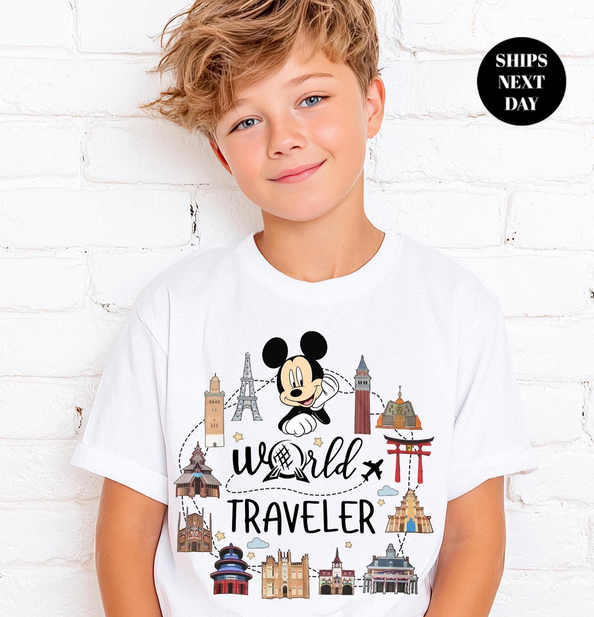 A young boy wearing a white t-shirt with a Mickey Mouse design and the text "World Traveler" printed on it.