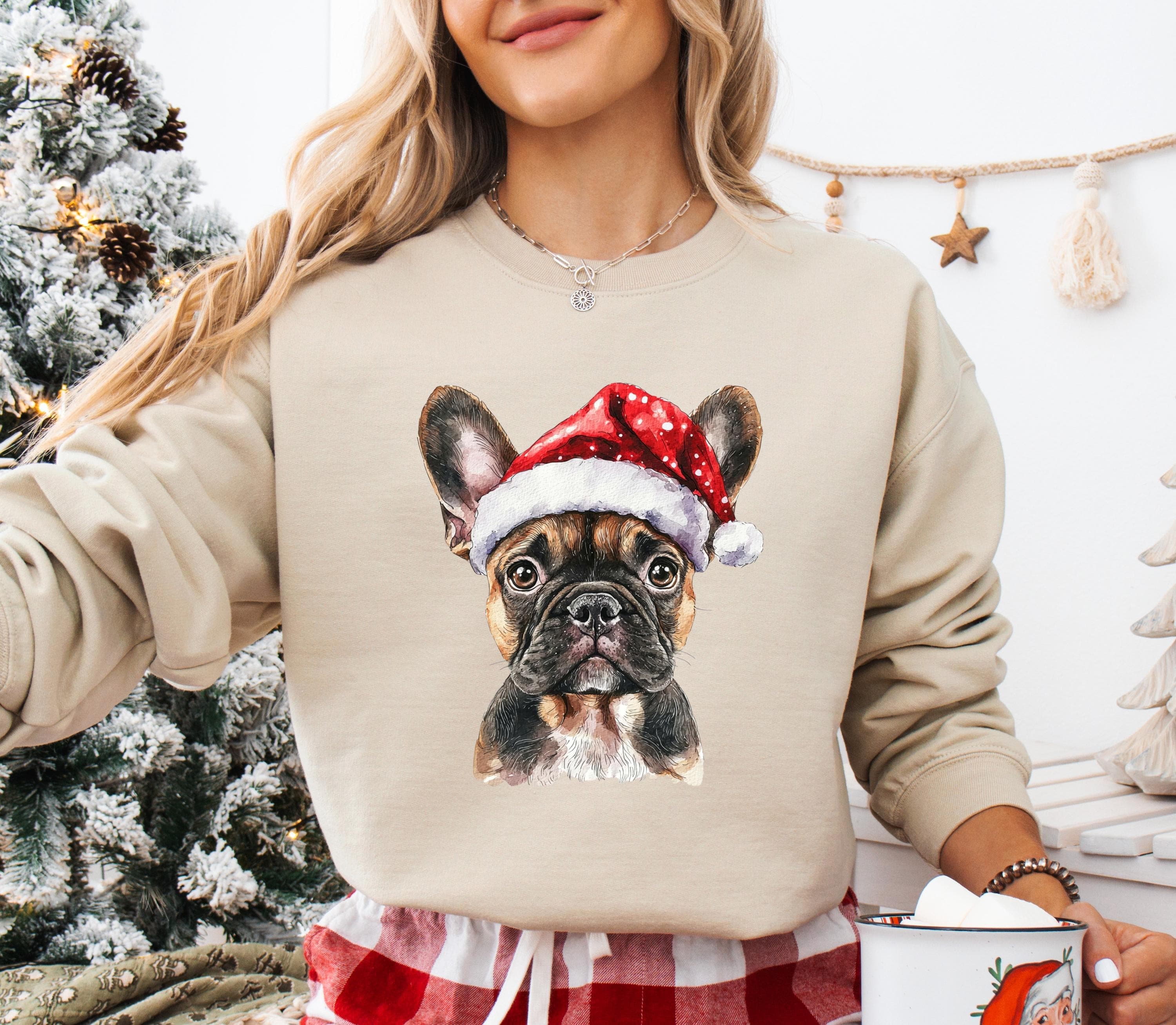 A woman wearing a beige sweater with a printed image of a dog wearing a Santa hat.