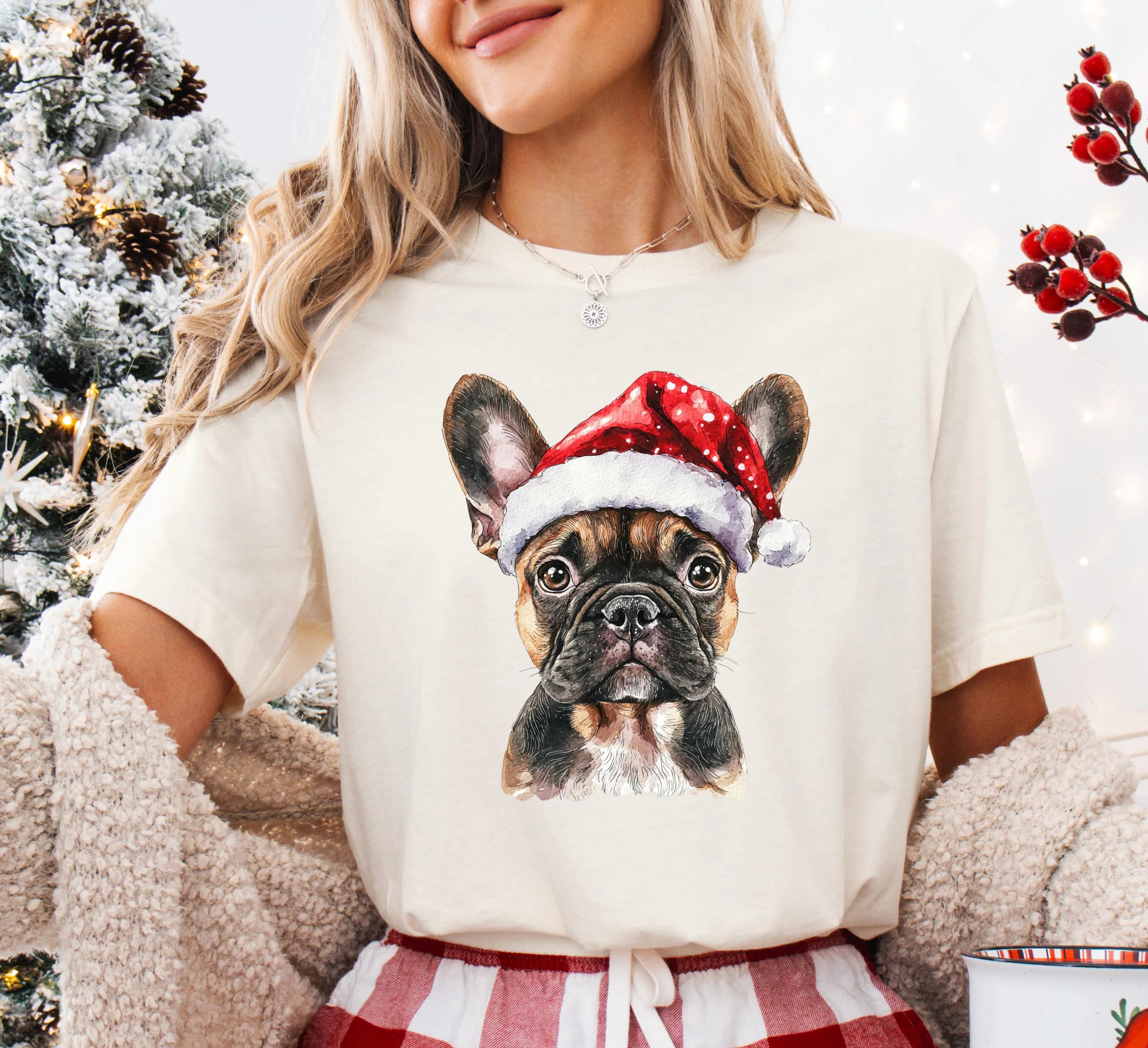 A woman wearing a white t-shirt with a picture of a dog wearing a Santa hat.