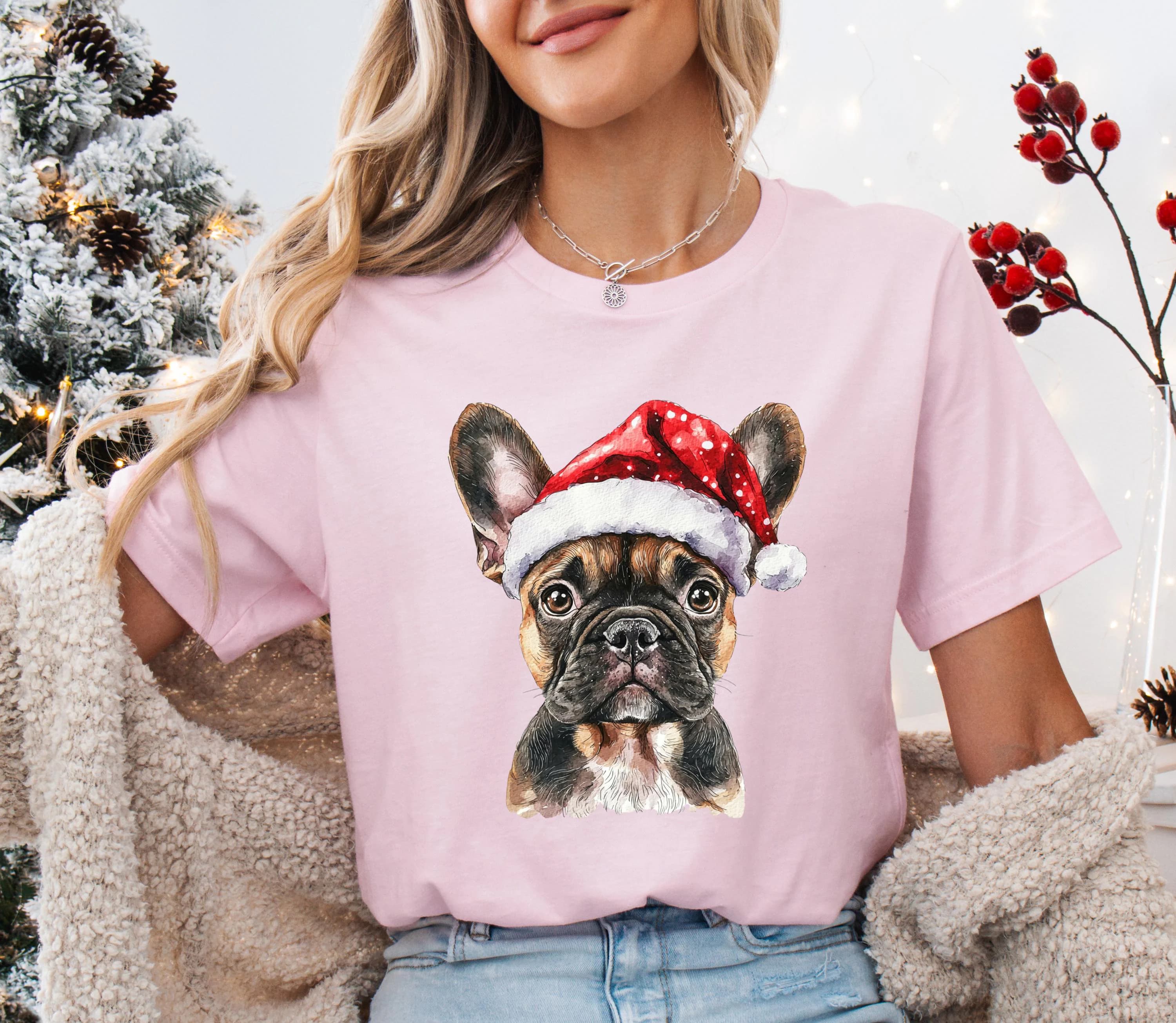 A woman wearing a pink t-shirt with a picture of a dog wearing a Santa hat.