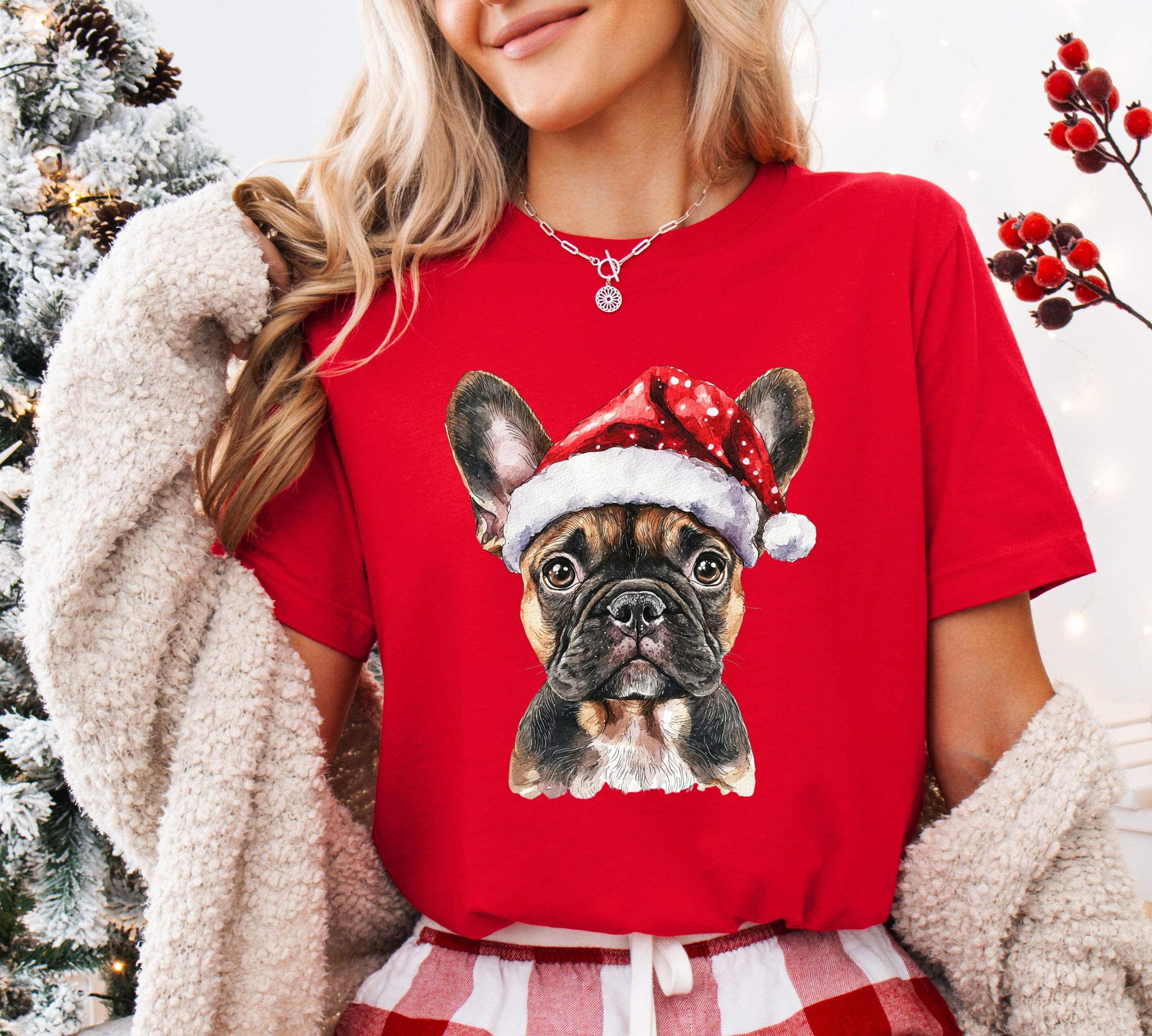 A woman wearing a red t-shirt with a picture of a dog wearing a Santa hat.