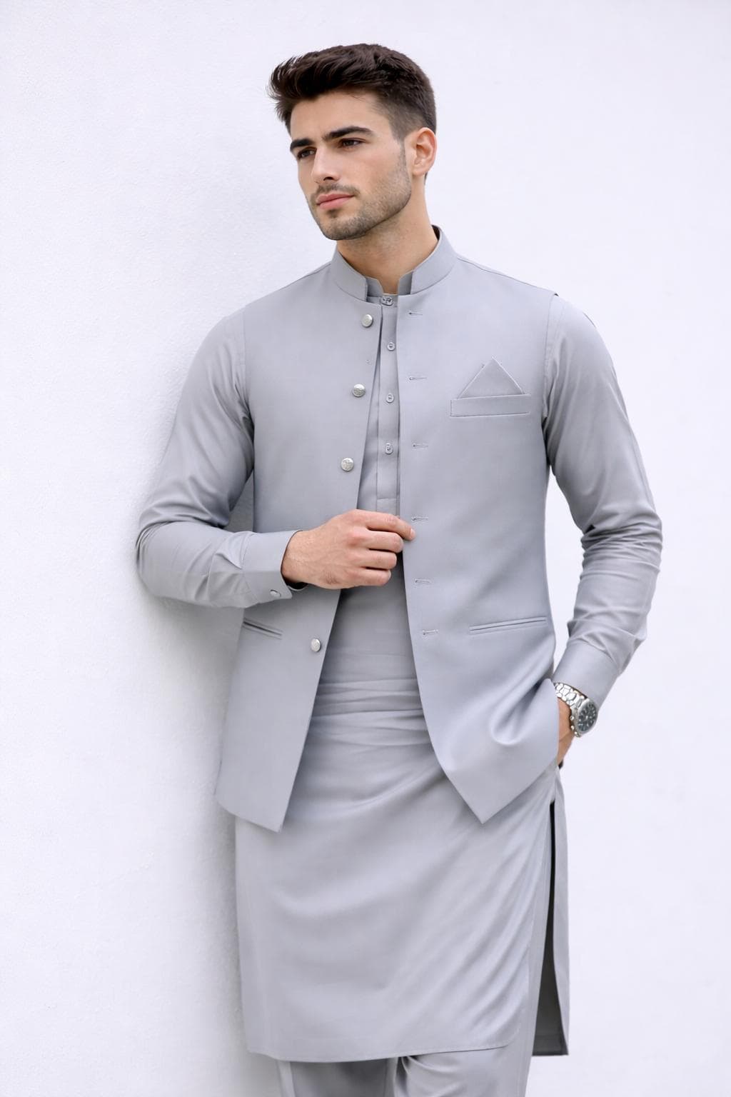 Full length view of ash grey kurta pajama with sleeveless Nehru jacket, modern Pakistani wedding attire for men.