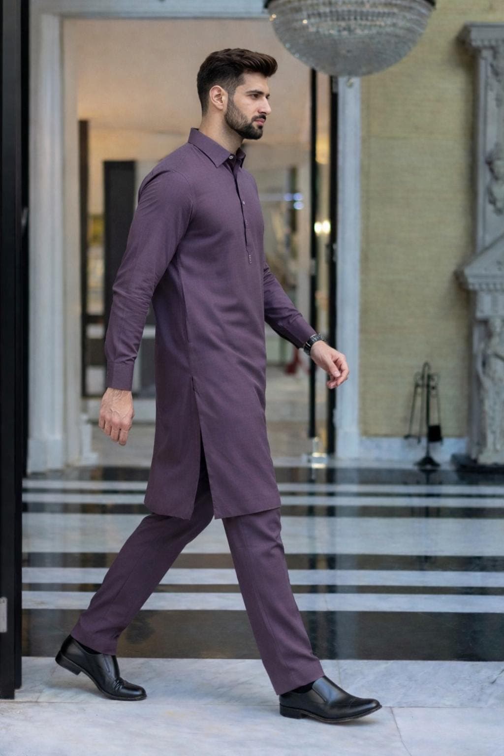 Male model walking in luxury plum purple kurta pajama set with slim fit trousers and black formal shoes.