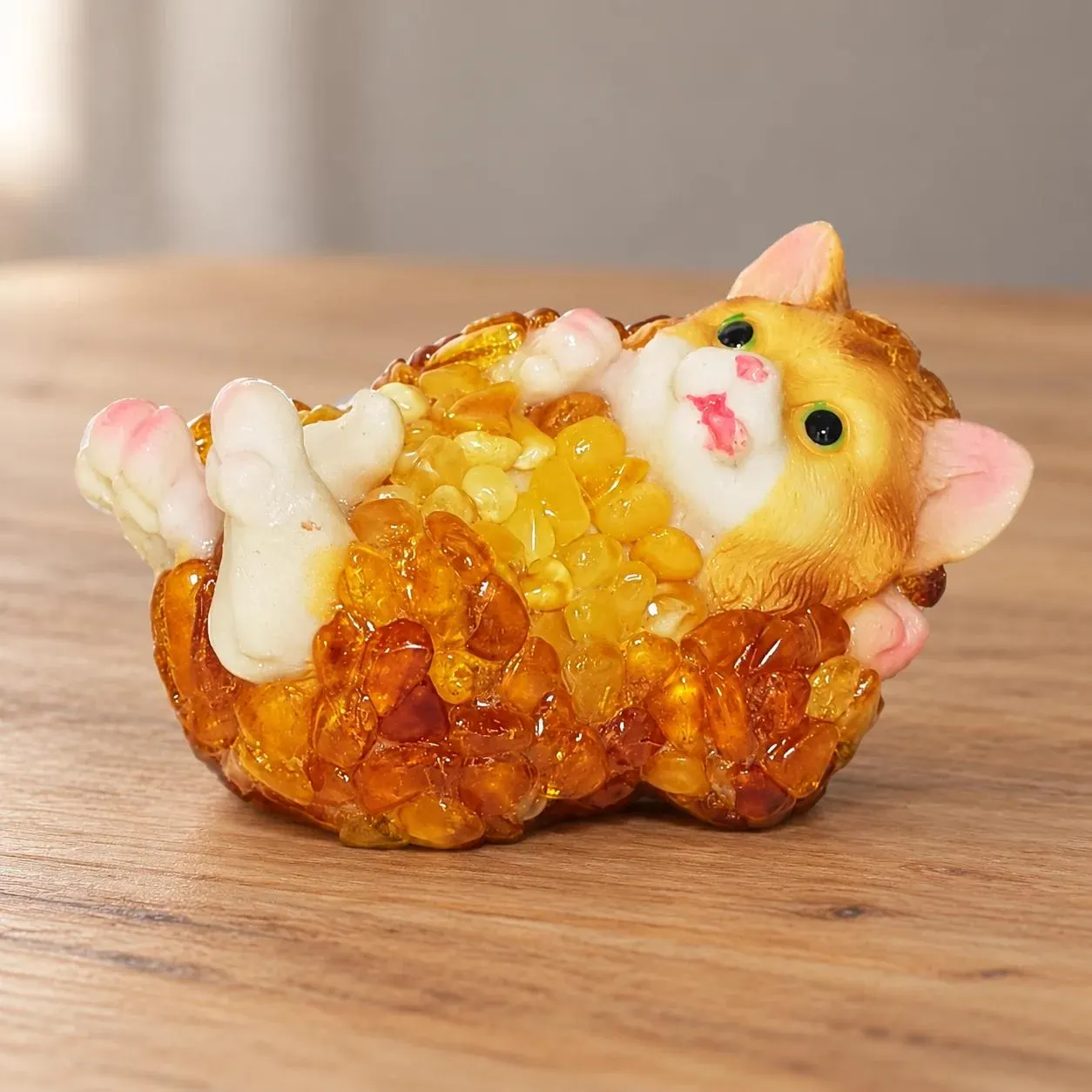 Baltic amber cat figurine on its back on a shelf in a softly lit home interior — handmade in Brooklyn by KIZIMA®