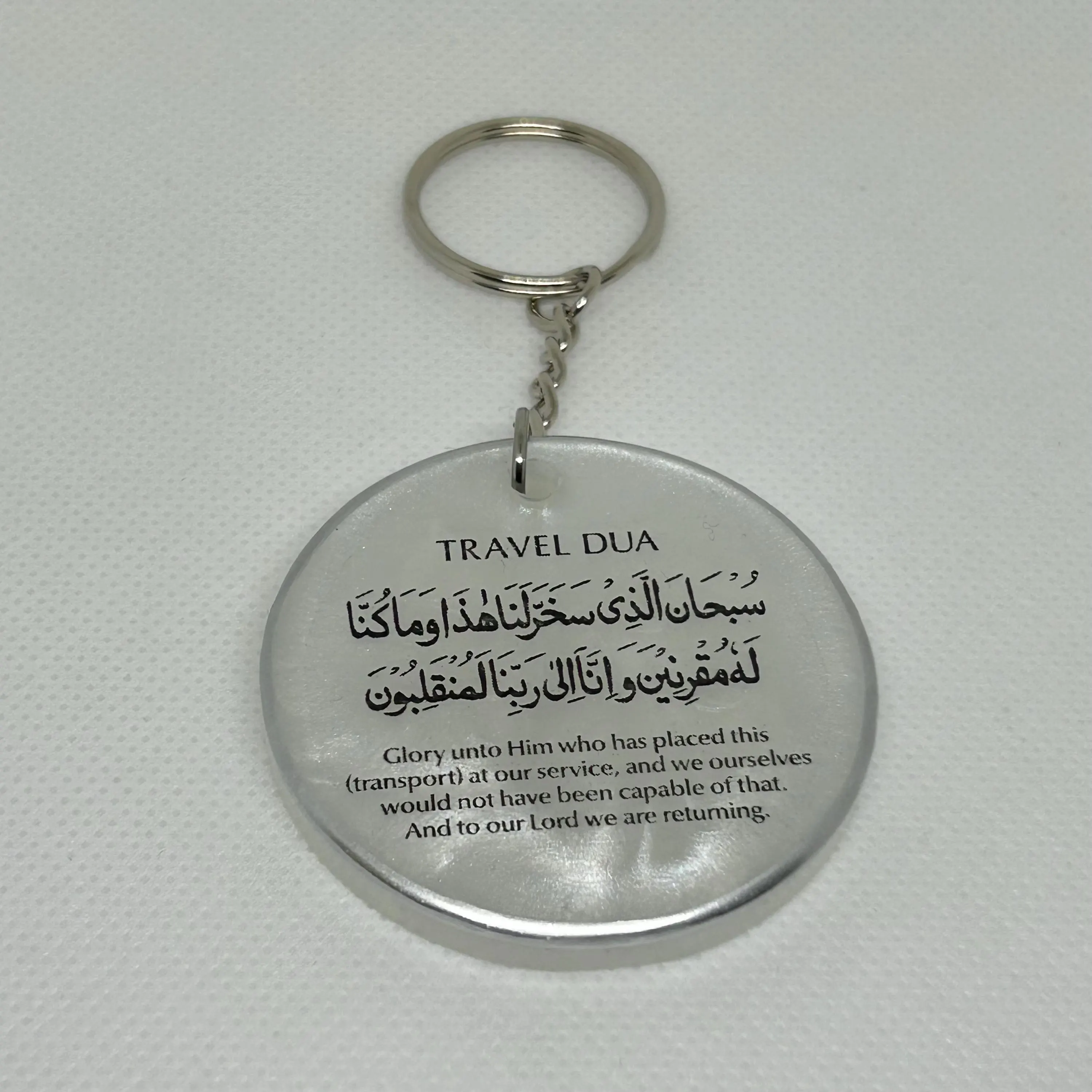 Round 5cm resin keyring in pearlescent white with the Arabic travel dua with English translation in black text with a silver edge