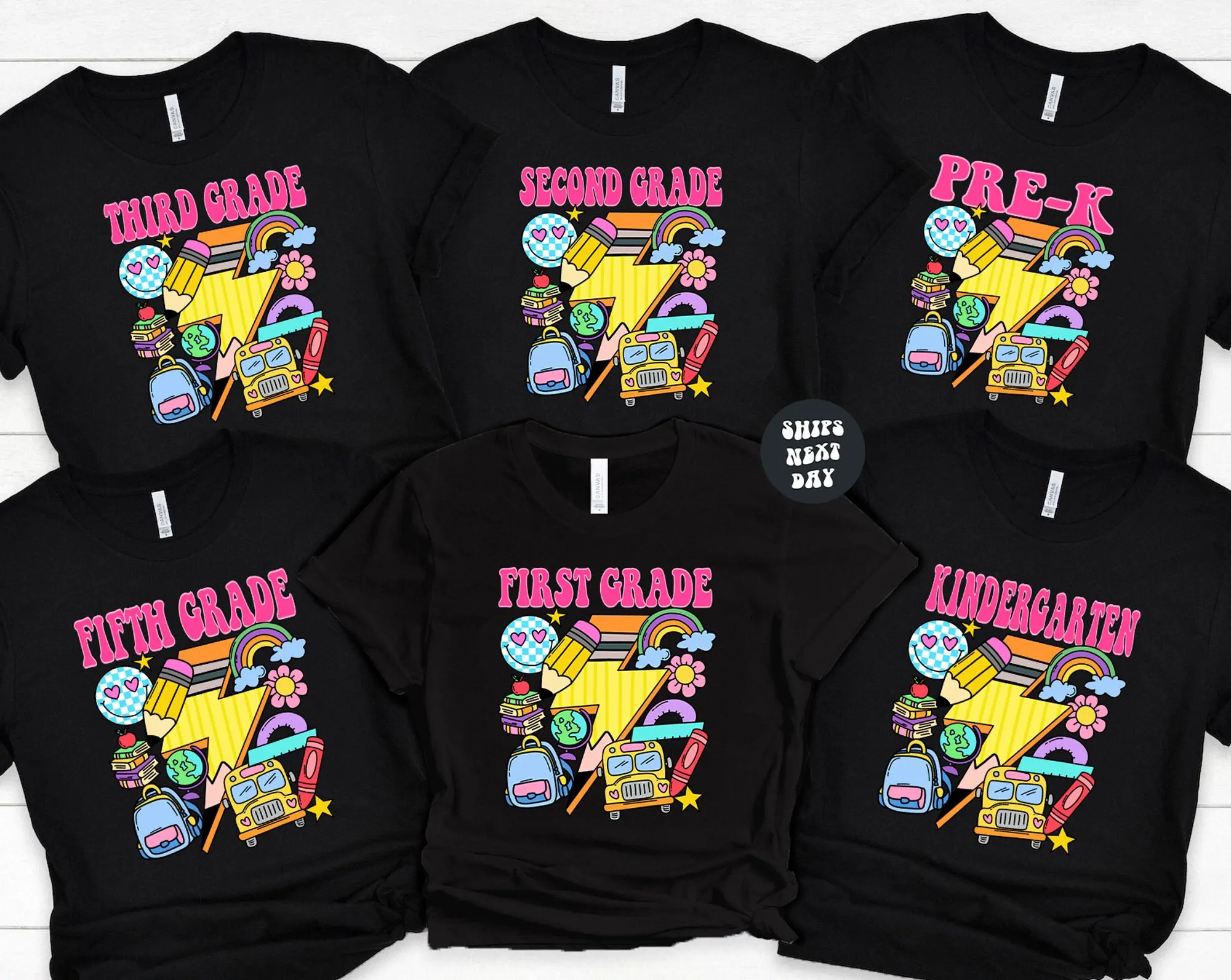 A collection of black t-shirts with colorful illustrations and text, likely representing different grade levels in a school setting.