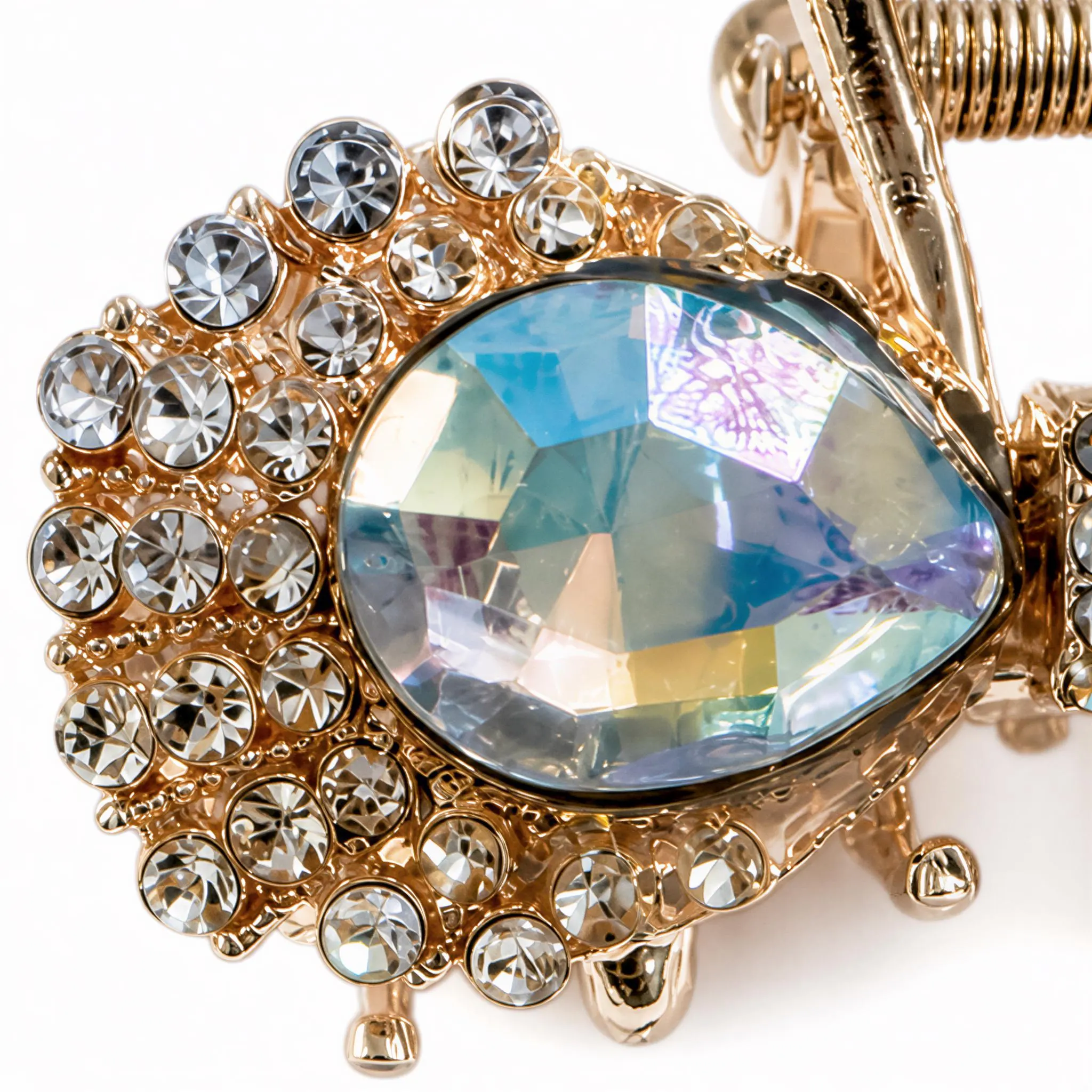 A close-up image of a decorative piece featuring a large, multicolored gemstone surrounded by smaller, clear gemstones.