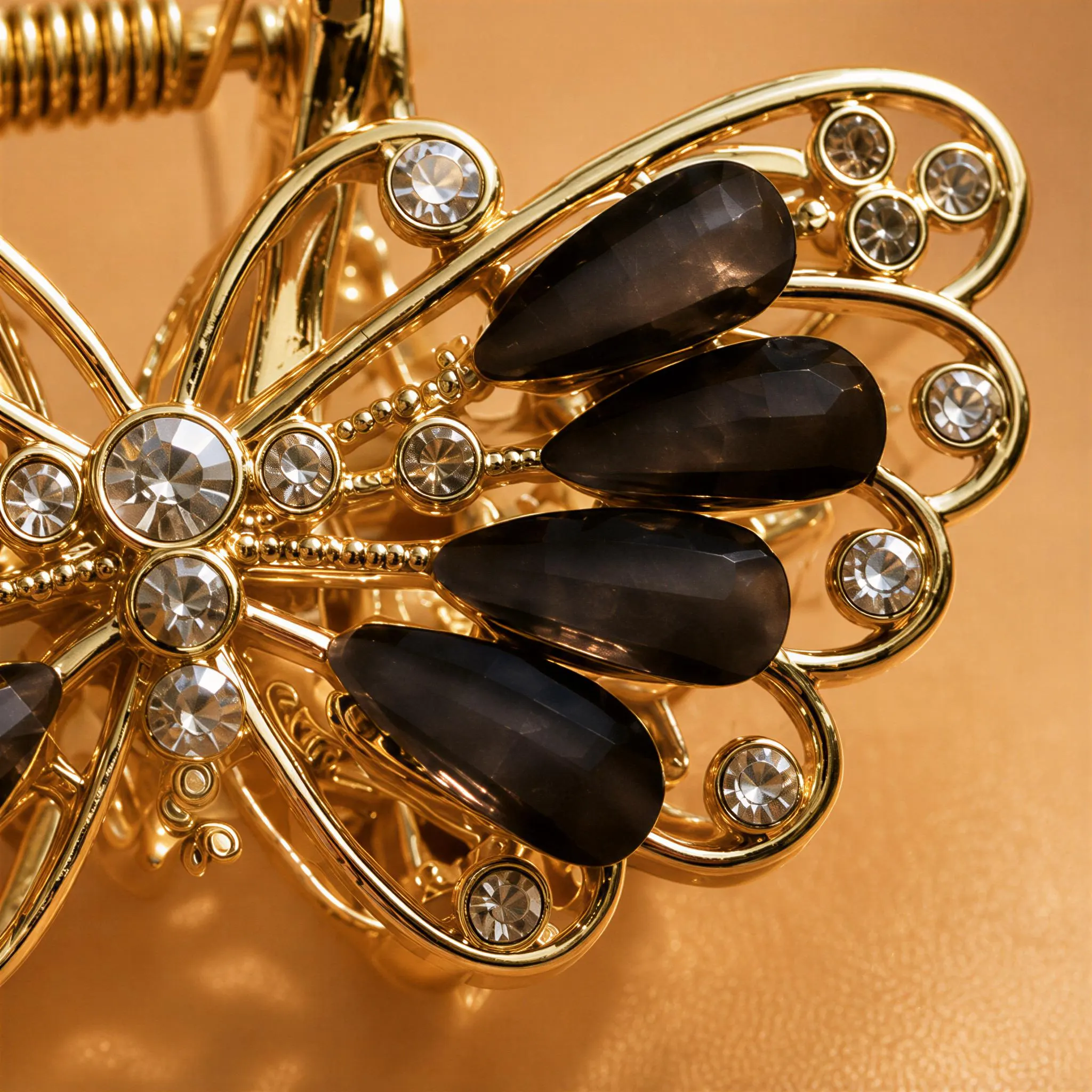 A close-up view of a decorative piece featuring a butterfly-shaped design with black gemstones and gold accents.