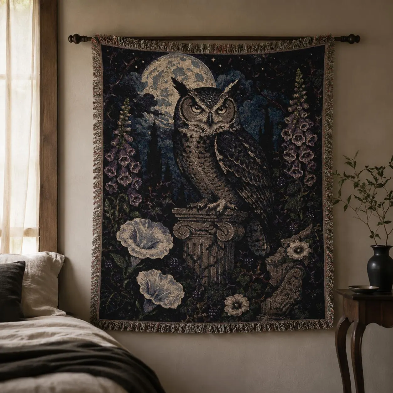 Vertical woven blanket wall hanging with a large owl on a stone column beneath a full moon, surrounded by purple foxglove-like flowers, white moonflowers, dark foliage, starry night sky, and fringed textile edges.