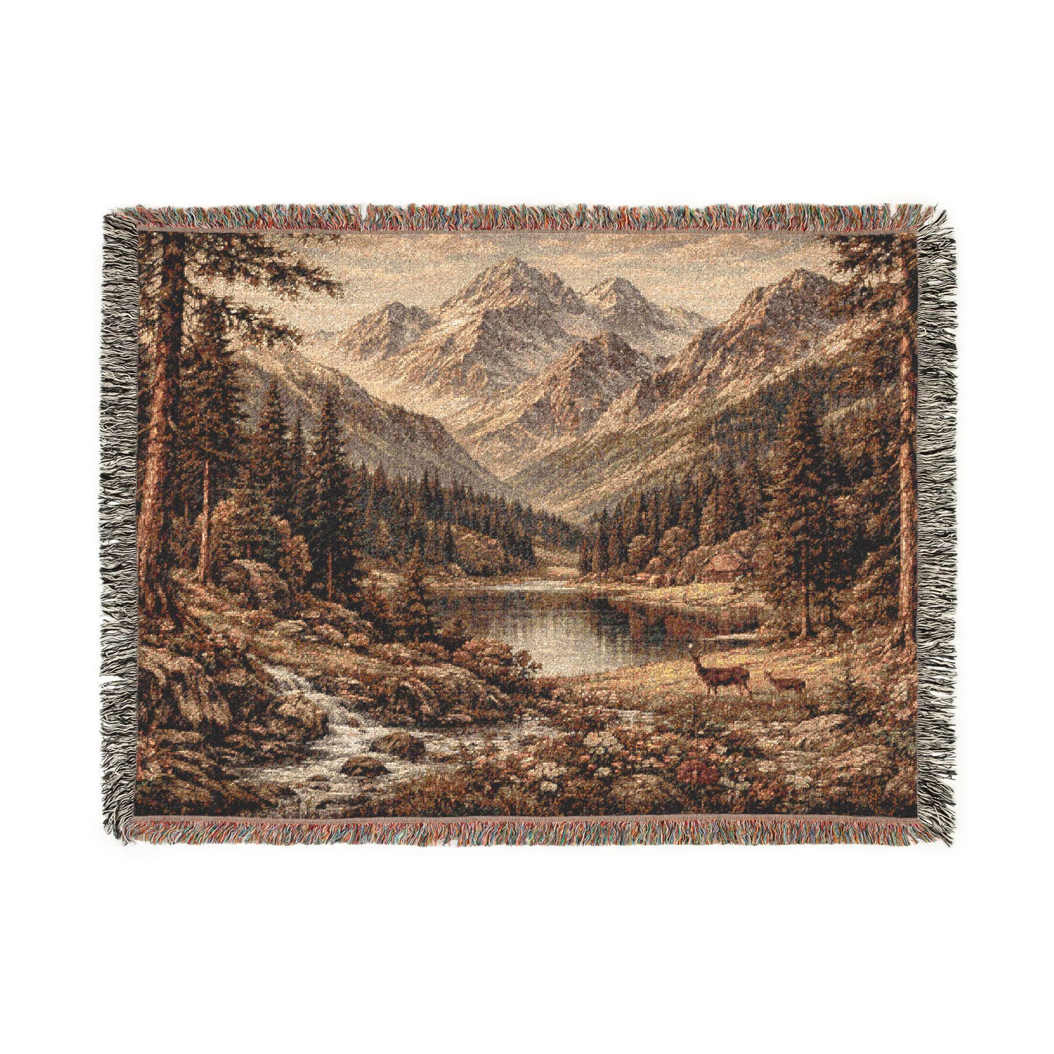 Woven tapestry blanket showing a vintage mountain landscape with an alpine lake in the center, evergreen forest on both sides, rocky stream in the foreground, and layered mountain peaks in the distance. Warm earthy tones and detailed woven texture with fringed edges. Works as tapestry wall art or woven wall hanging for cabin lodge decor, rustic home style, mountain house wall decor, and nature-inspired bedroom or living room accent. Great gift for outdoor lovers.