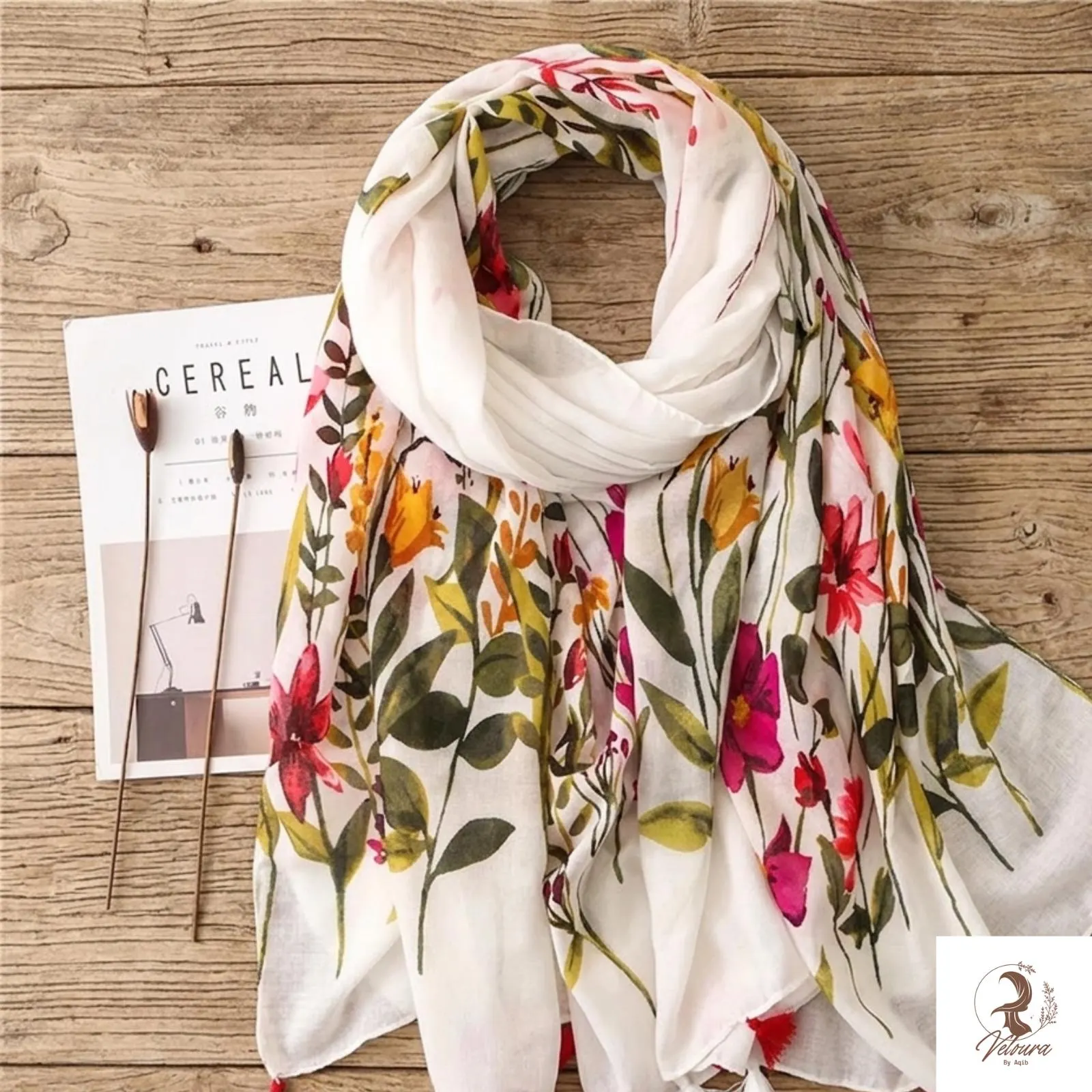 Large floral cotton scarf with tassel trim draped over shoulders
