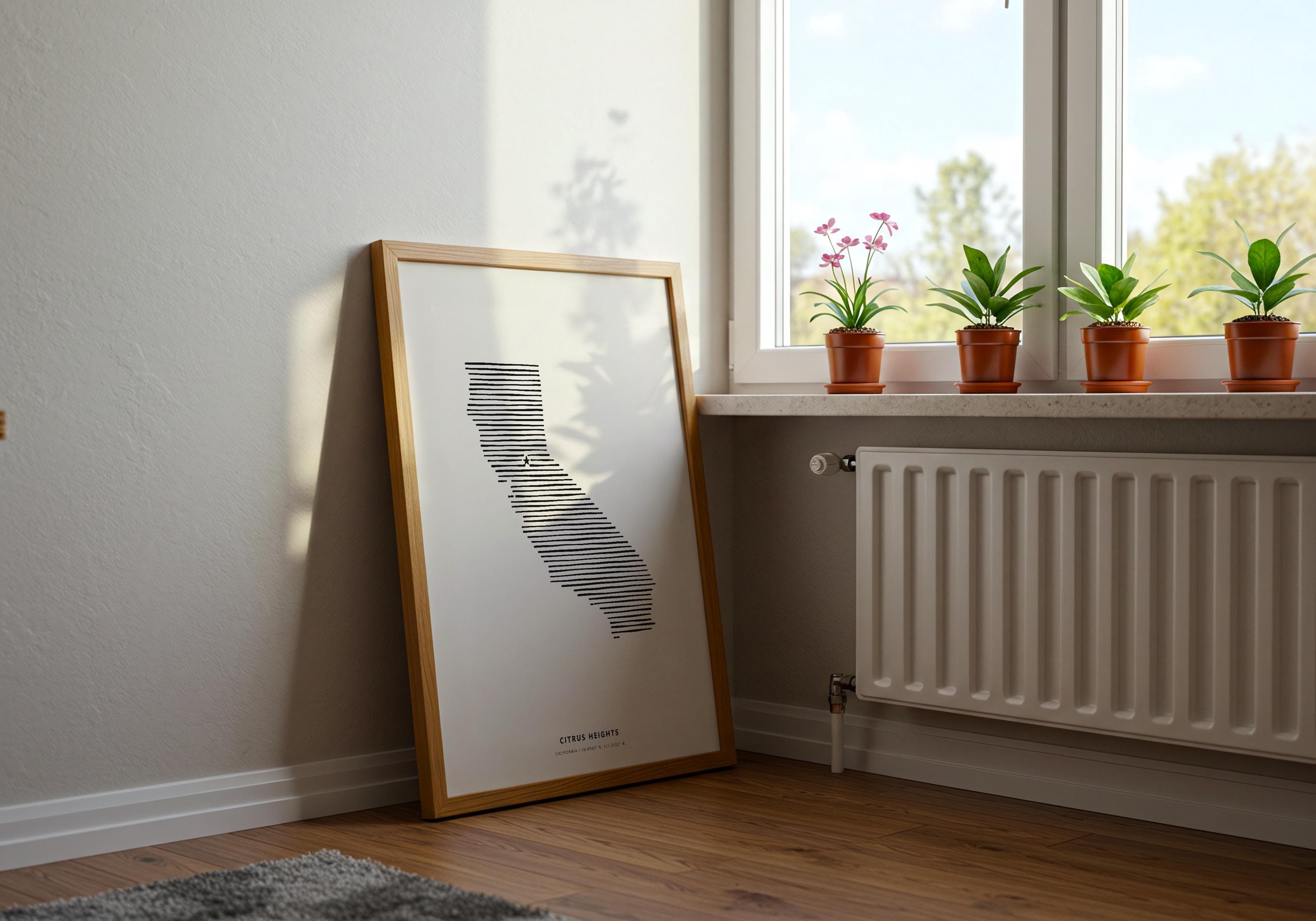 Interior styling shot of the minimalist California hometown print resting near white baseboards and hardwood floors.