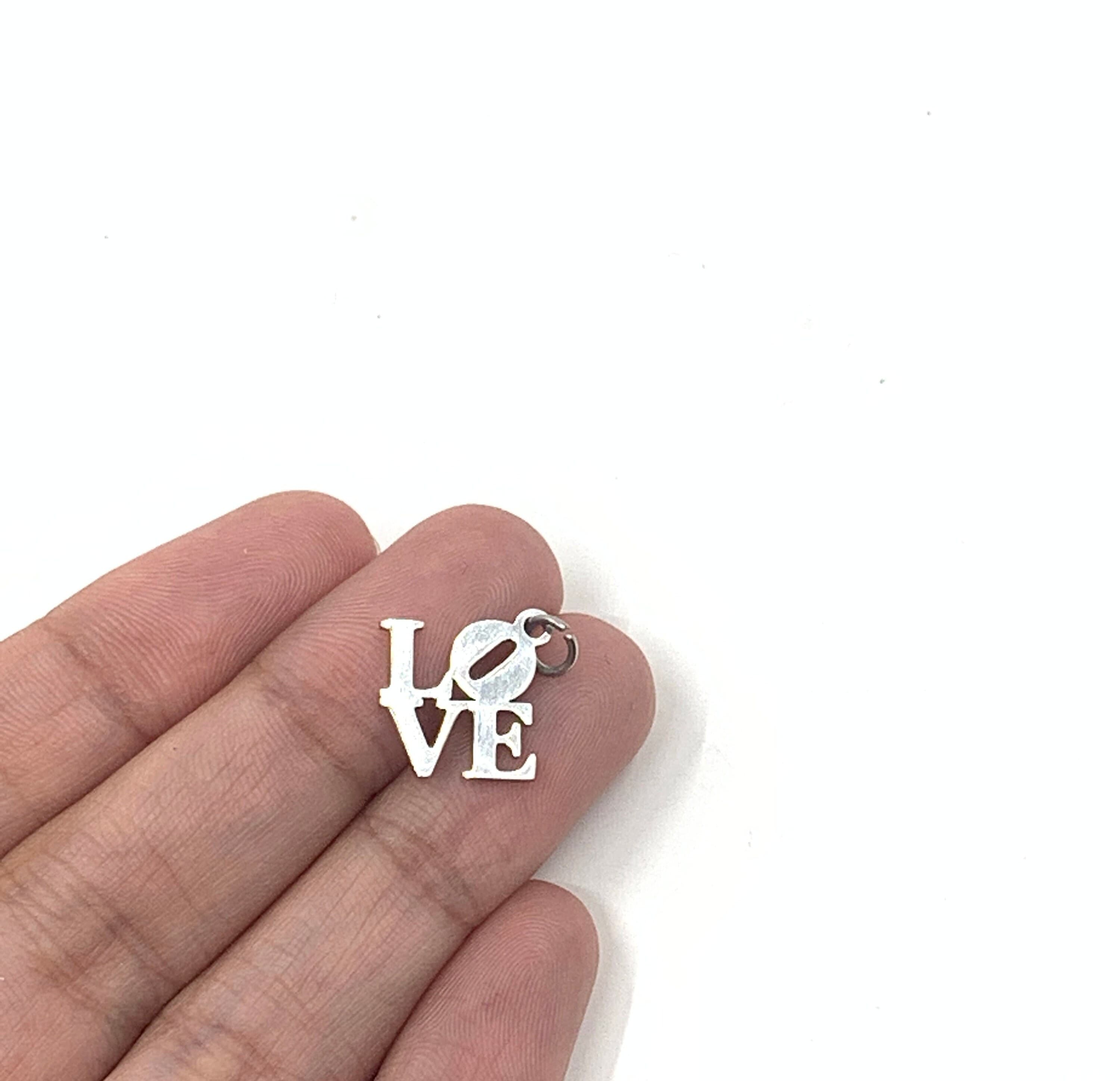 Love word charm on hand for reference