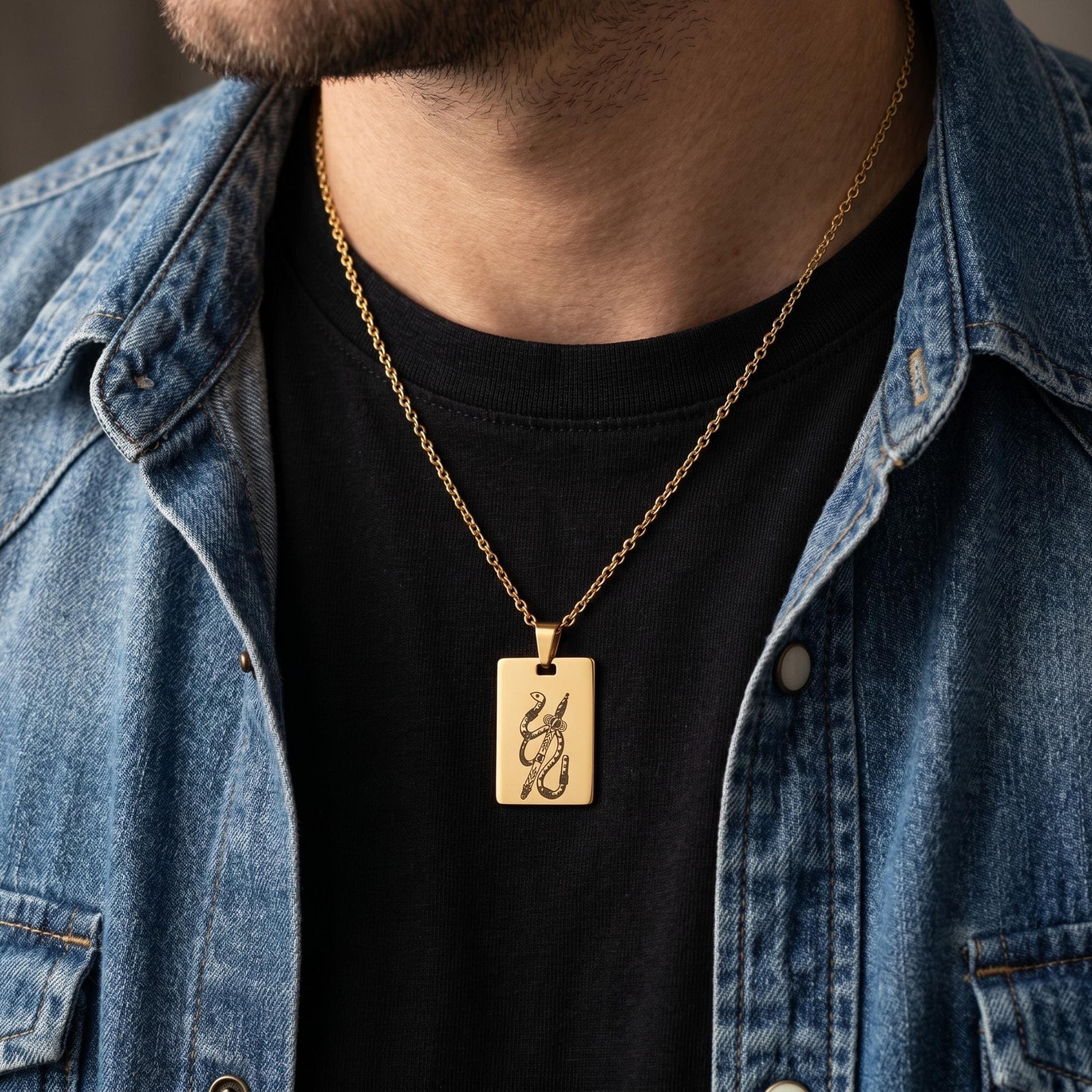 A gold necklaces with rectangular pendants featuring the Spada (Ace of Swords) Scopa Briscola Italian playing cards design worn by a men in a black t-shirt.
