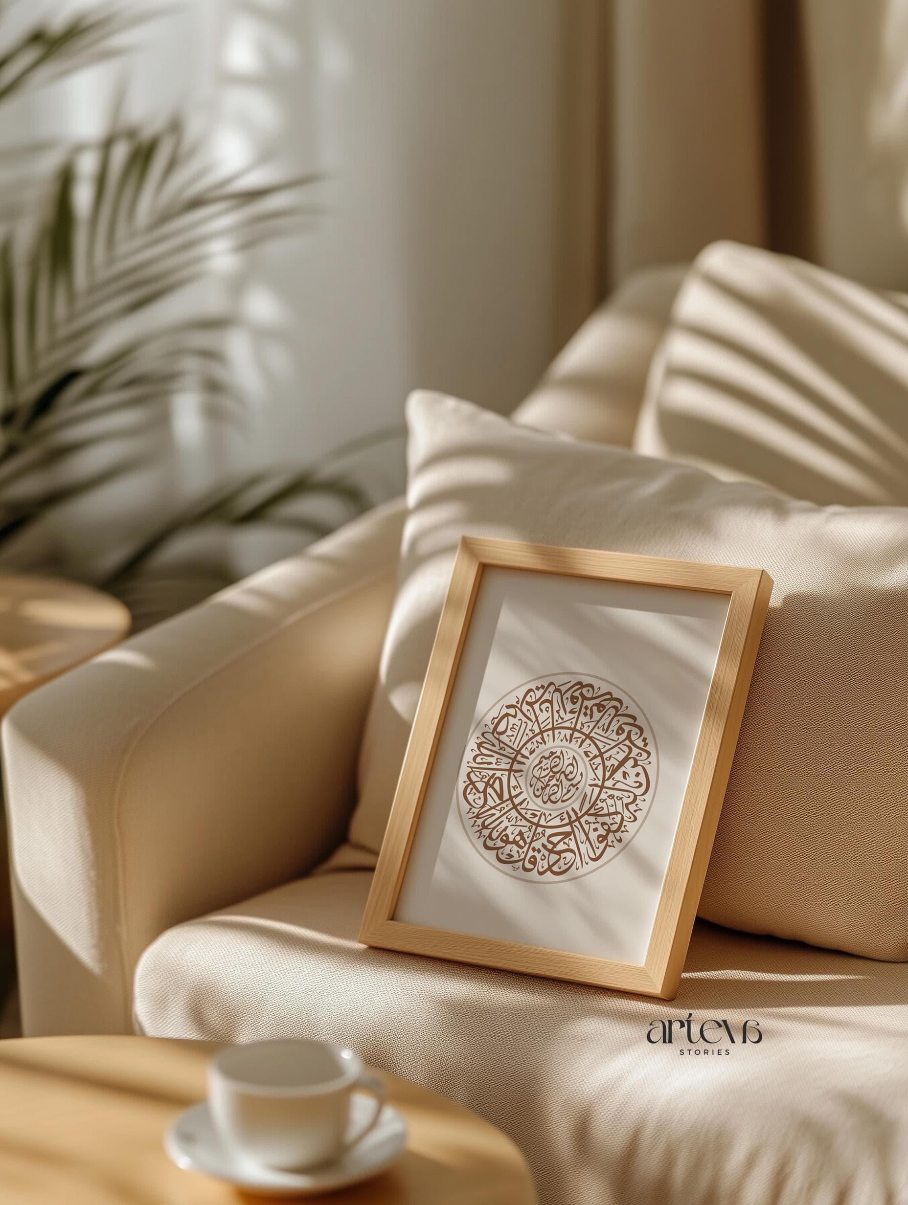 A cozy living room scene with Surah Al Ikhlas earthy calligraphy artwork framed in wood, resting on a beige sofa with warm natural lighting.