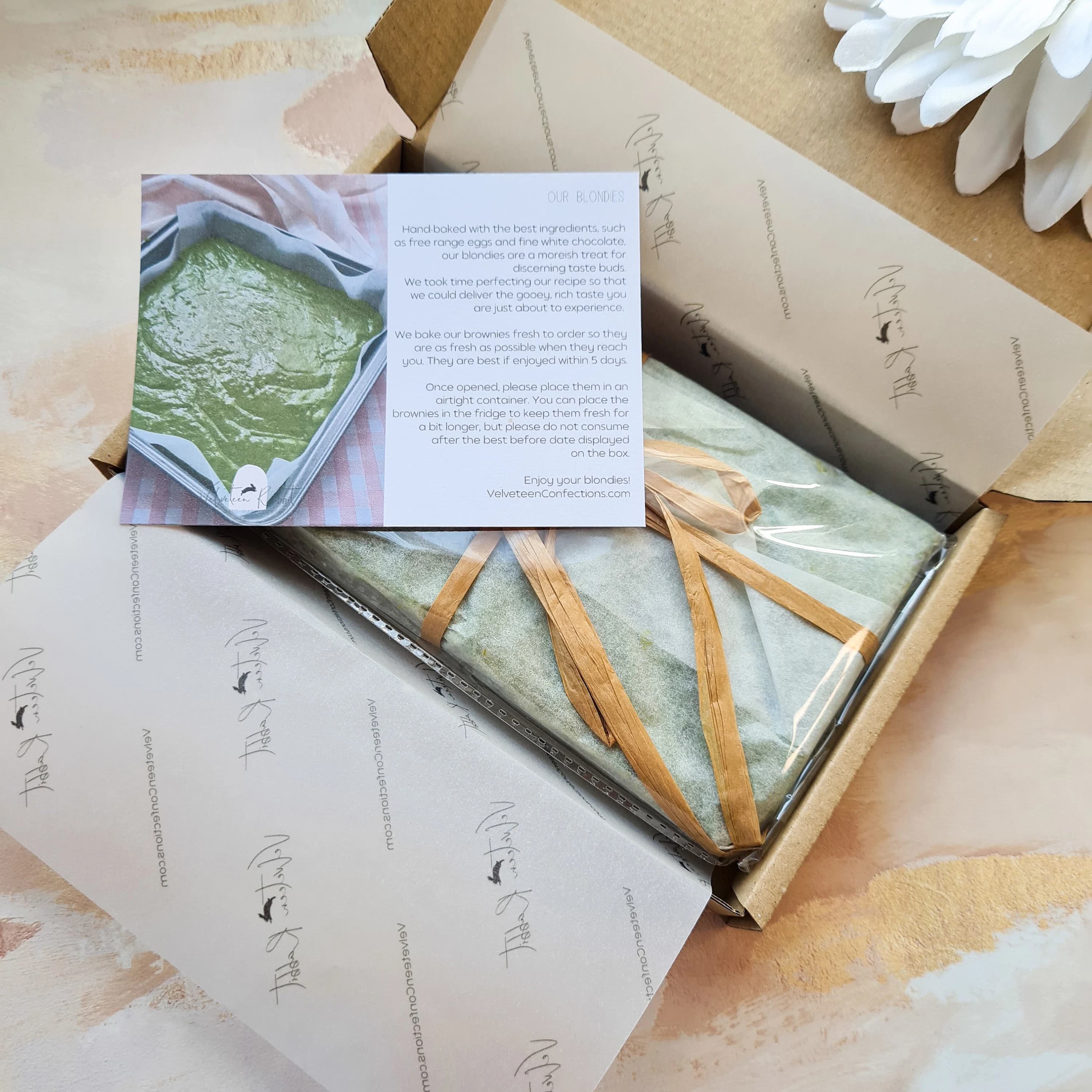 Matcha blondie bites, made with Culinary Grade Organic Japanese Matcha, in a gift box containing 18 bites, this picture shows the inside of the box, with the matcha blondies neatly wrapped, an information card about the product is included.