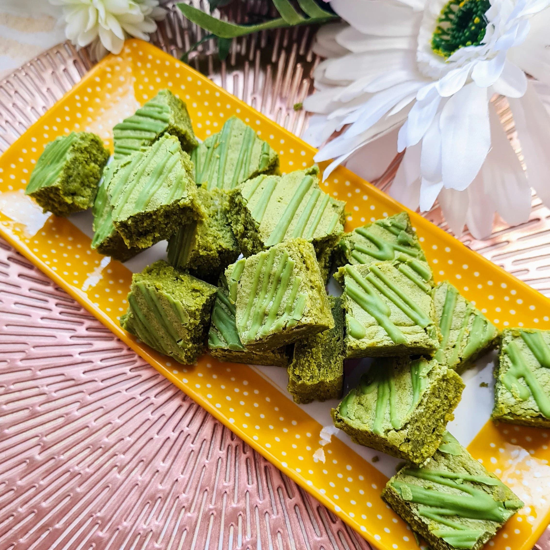 Matcha Blondie Bites, green in colour made with organic Japanese matcha, and served on a rectangular plate.