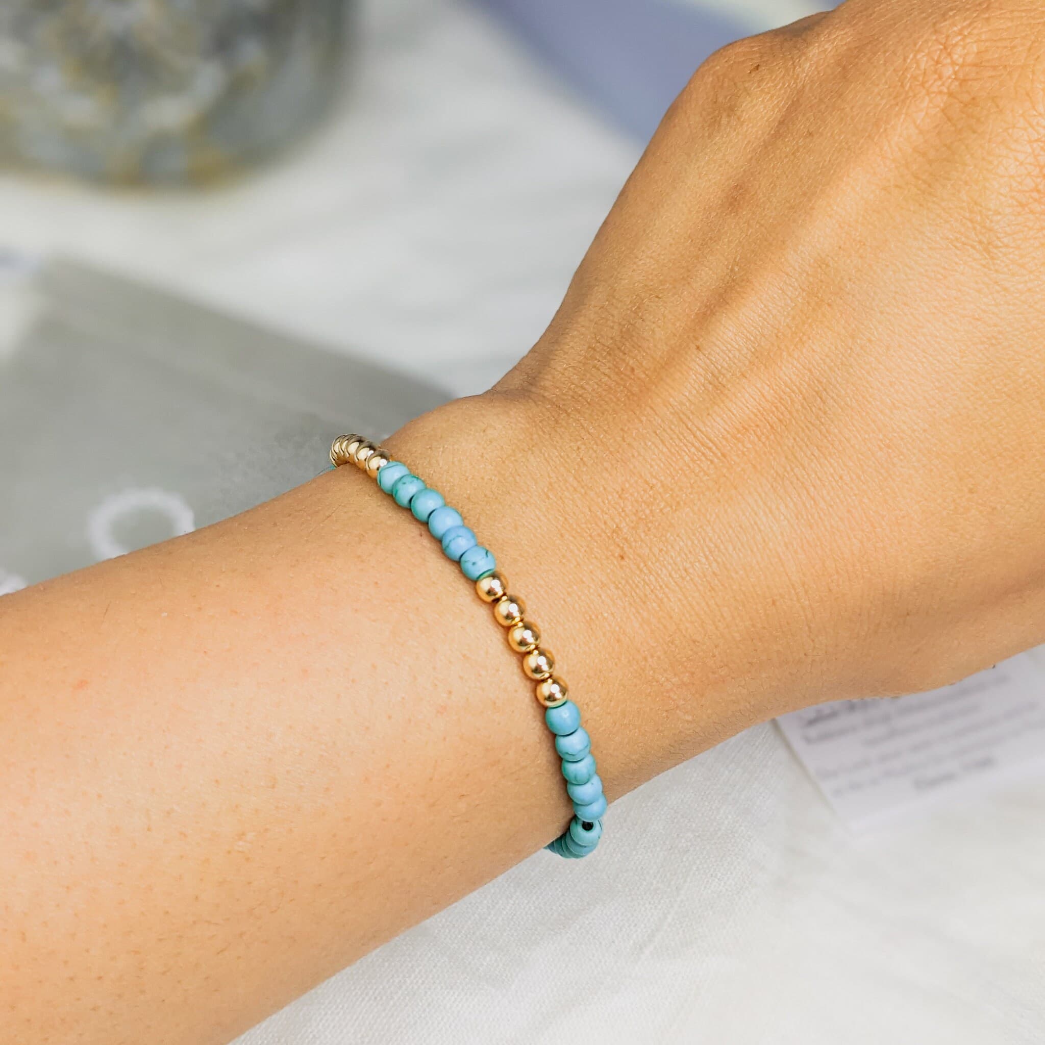 Tasbih Bracelet on wrist made with 33 turquoise and 14k gold filled tasbeeh beads. Bracelet is made with gold filled finishings and durable jewelry wire. Tasbih Bracelets are made with 1 to 2 extra bead spaces to support islamic prayer.