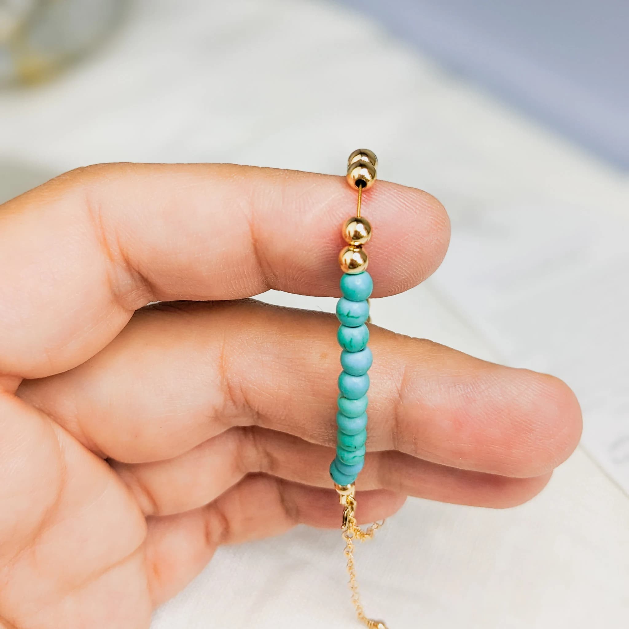 holding Tasbih Bracelet made with 33 turquoise and 14k gold filled tasbeeh beads. Bracelet is made with gold filled finishings and durable jewelry wire. Tasbih Bracelets are made with 1 to 2 extra bead spaces to support islamic prayer.