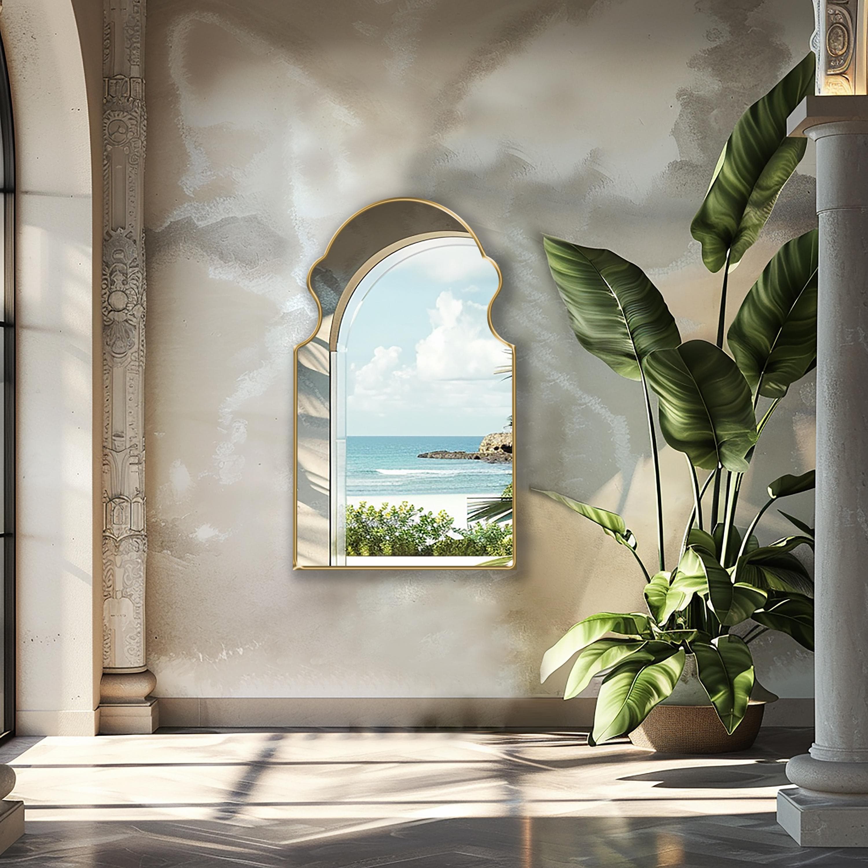 Bohemian Mirror with gold frame finish hung on the wall of a terrace next to the sea.