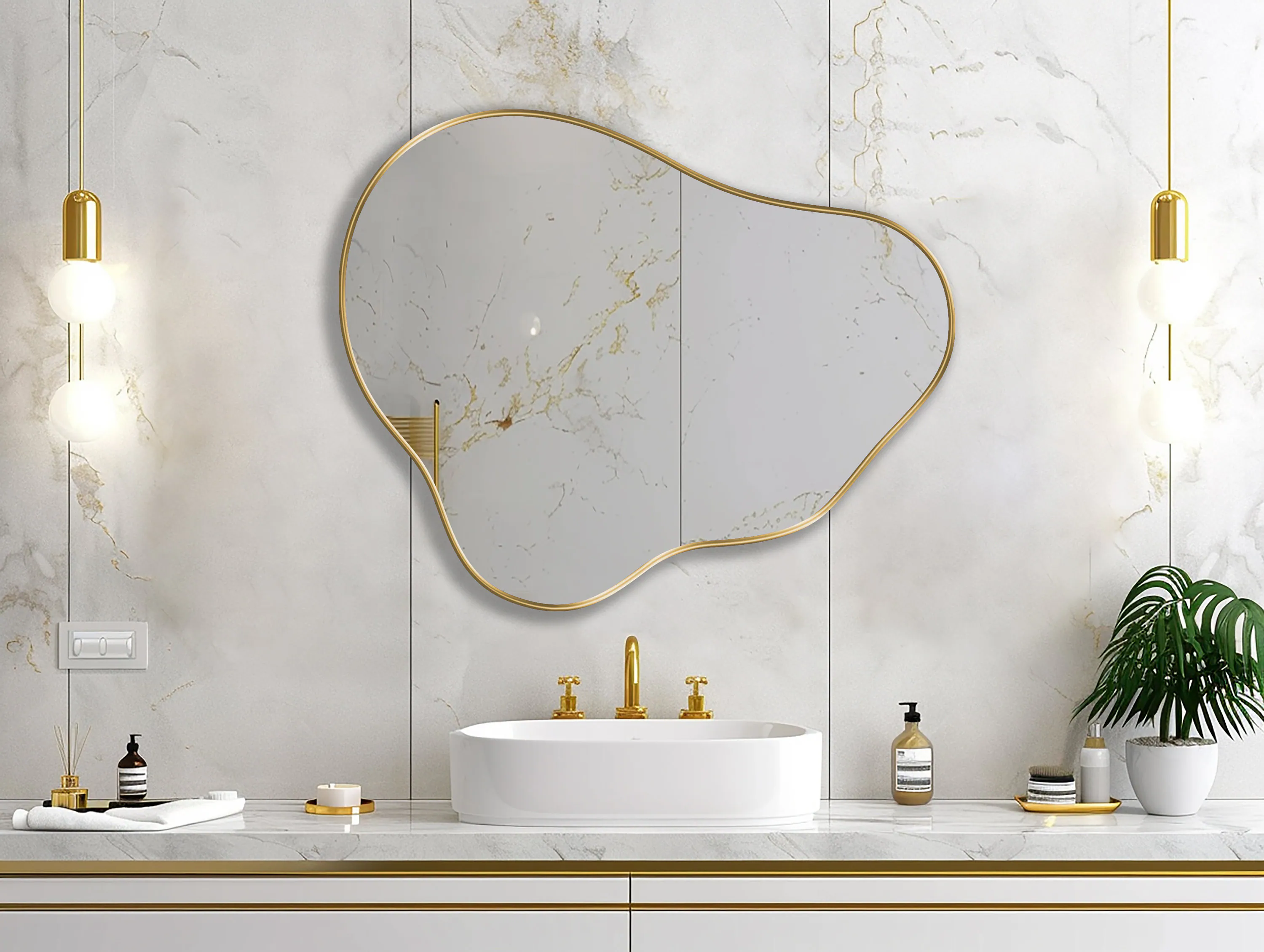 Organic Pebble Mirror with gold frame finish hung on the wall of a bathroom, over a vanity.