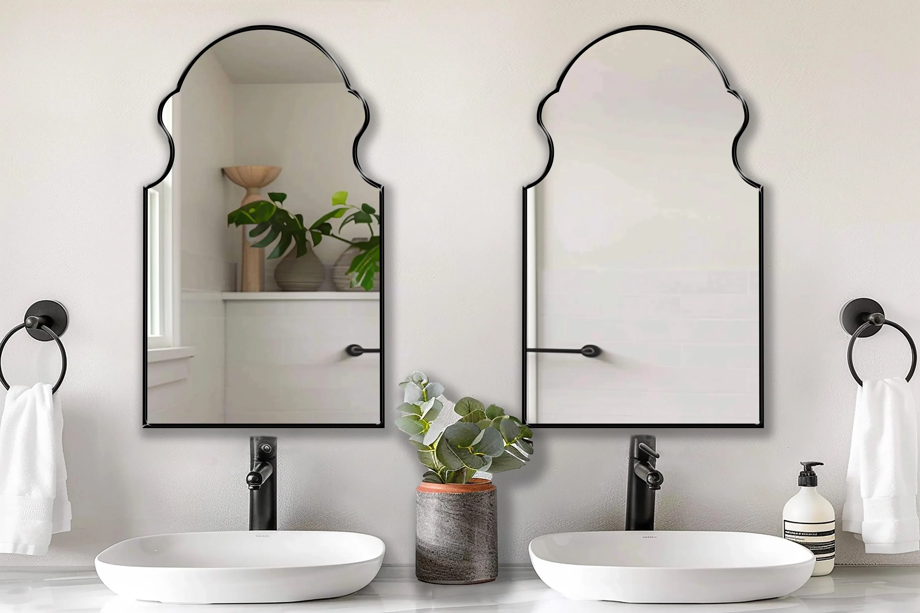 Two Bohemian Mirrors with black frame finish hung on the wall of a bathroom over a double vanity.