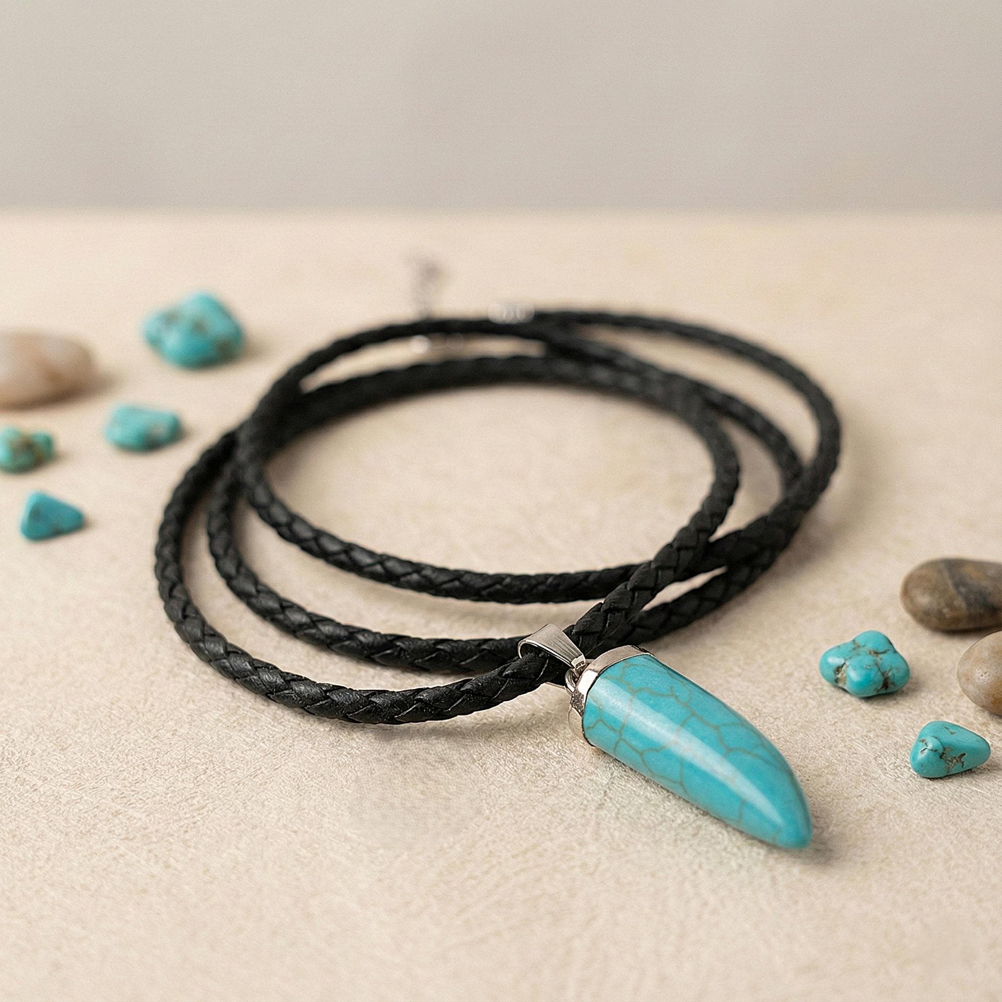 Braided black leather necklace cord with silver tone bail holding a synthetic turquoise spike charm, minimalist beach jewelry for summer.