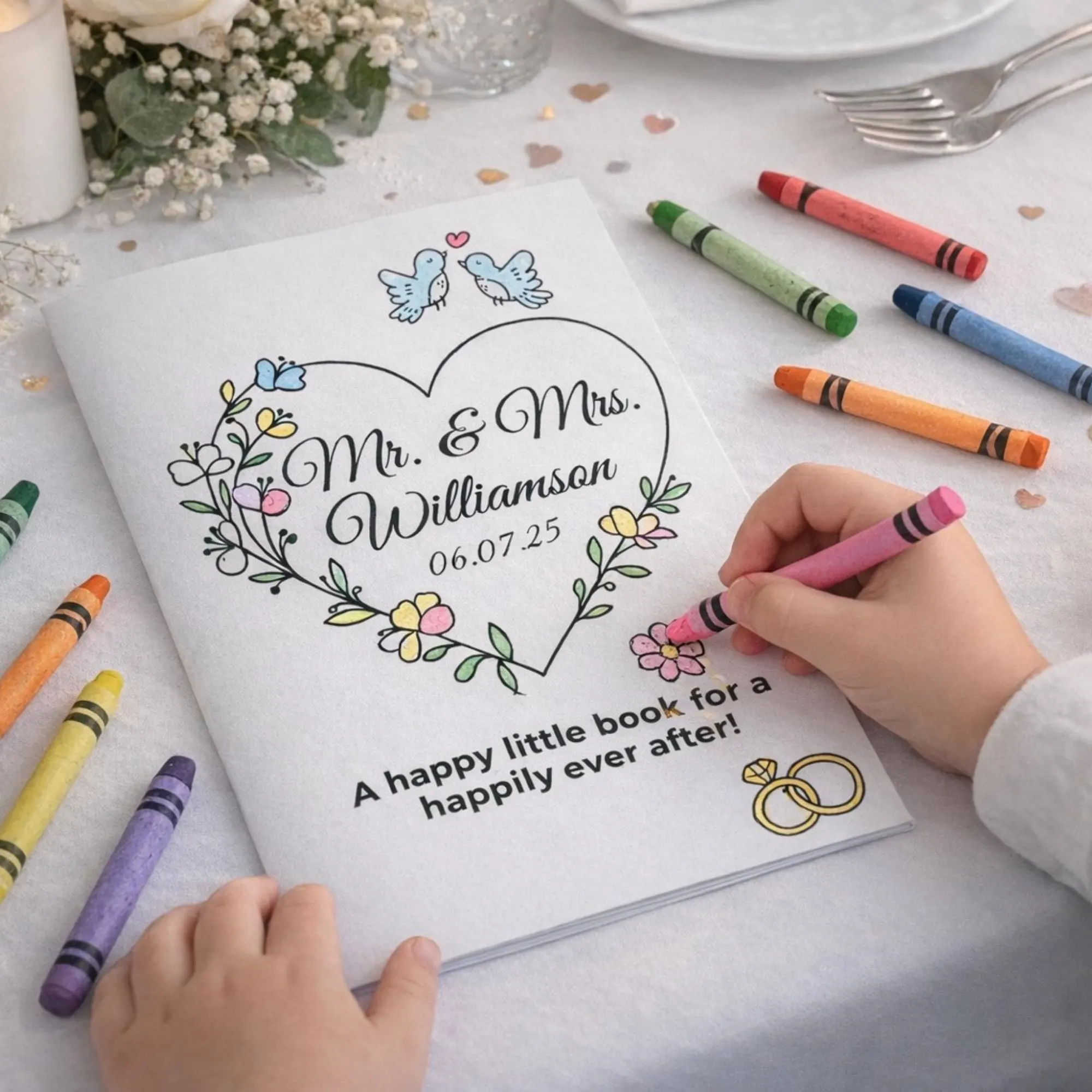 Child's hands coloring a personalized wedding activity book at a wedding reception table with scattered crayons baby's breath flowers and confetti hearts, printable kids wedding activity.