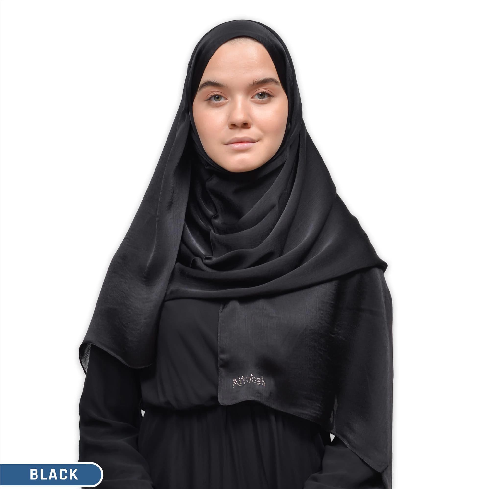 A black satin hijab with a subtle sheen. The hijab is draped over the head and neck, with the ends tucked in at the shoulders. The hijab has a small logo on the front that says "Altobeh".