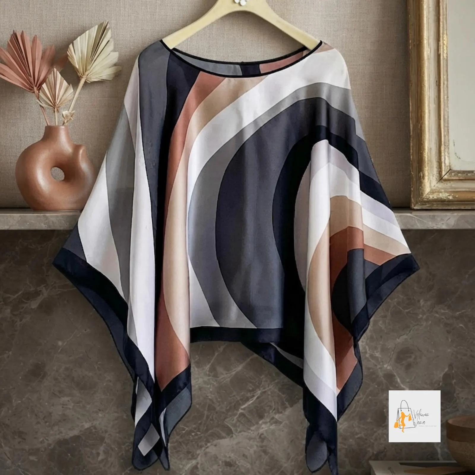 Oversized square poncho draped elegantly with attached hood.