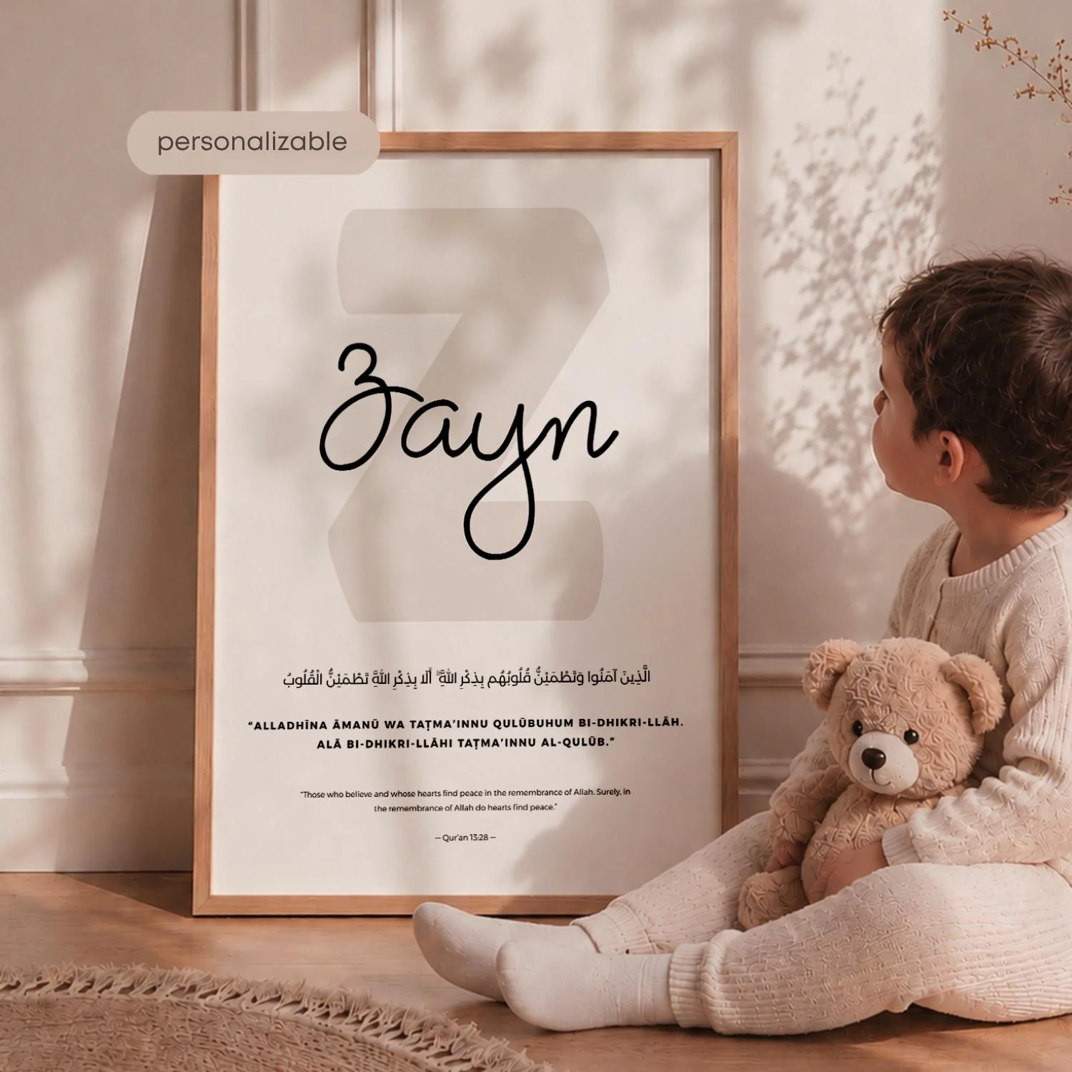 Custom Name Print Unique Name Design | Islamic Wall Print Quran Wall Art Muslim Baby Decor | Beige Islamic Print Arabic Name Wall Art: A framed print with the name "Zayn" in elegant script, set against a large "Z" shape. The print includes Arabic script and the word "personalizable". A child is seated beside the frame, holding a teddy bear.