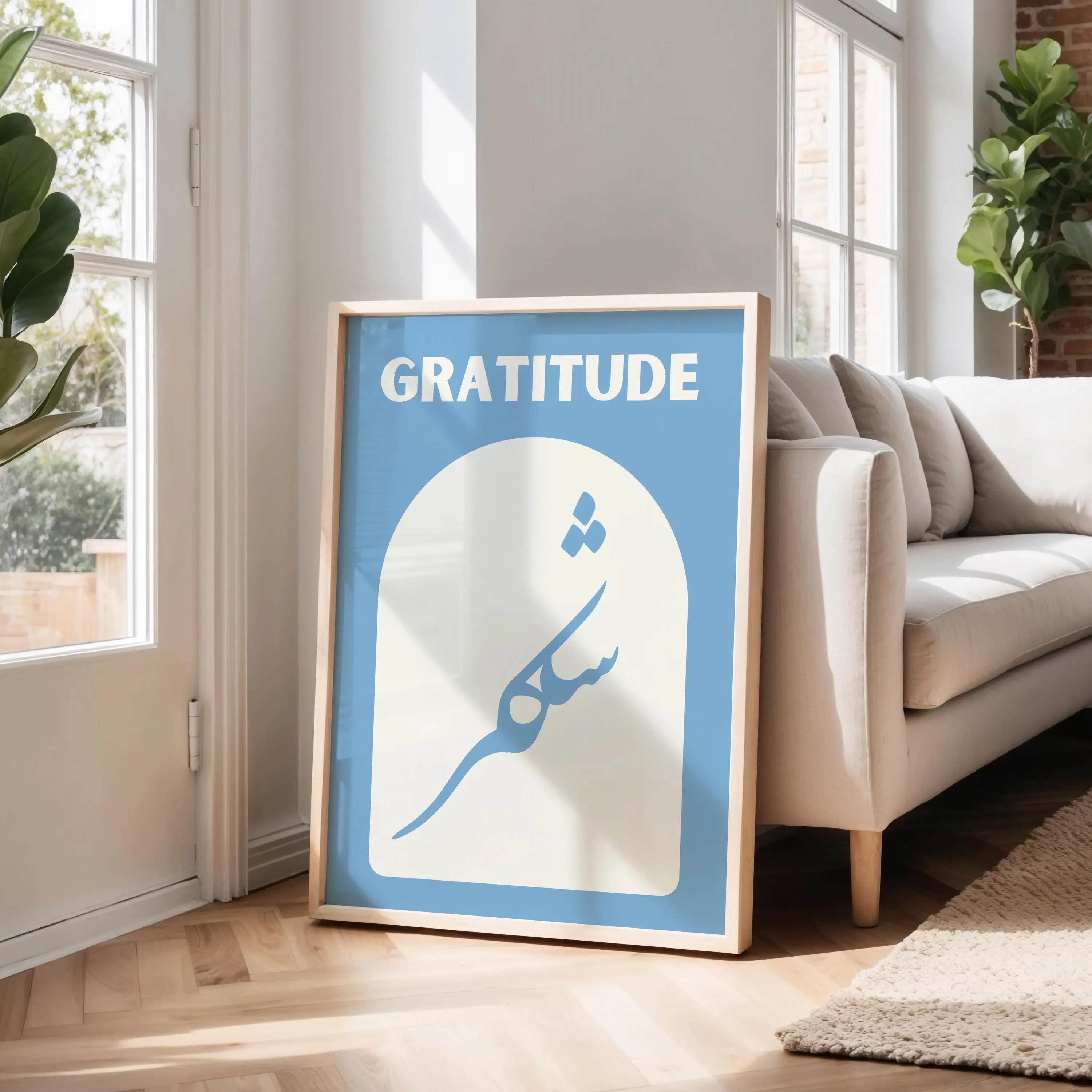 The artwork features a soft blue background featuring the word "GRATITUDE" in bold light beige letters at the top and the Arabic word for gratitude, "shukr" written elegantly below, inside an arched shape.