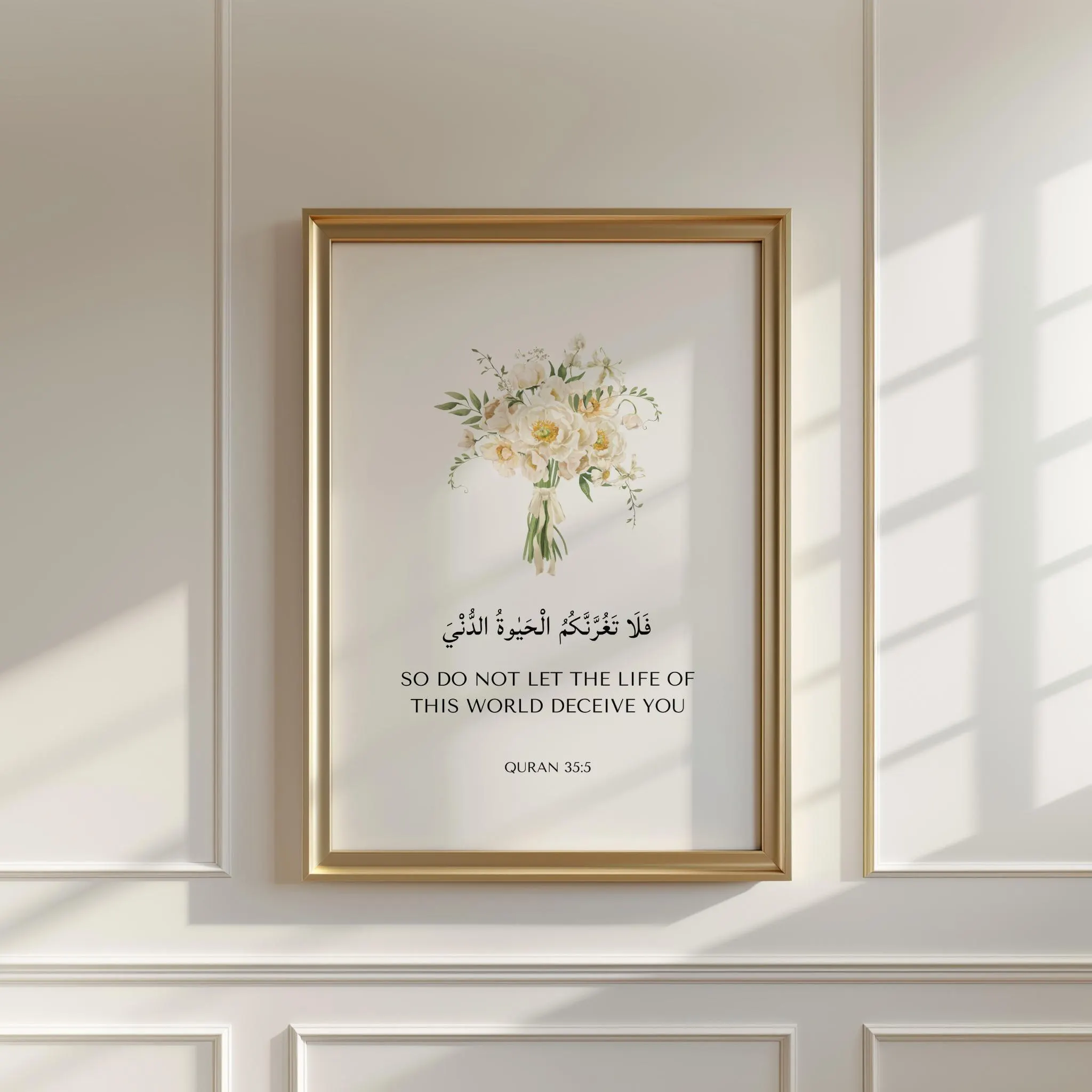 Framed islamic wall art piece featuring Quran Quote 35:5 with white flower bouquet. Displayed on a white wall. An ideal islamic art quran verse prints for islamic home decor, islamic wall decor, nursery art, or as ramadan eid gifts for muslims