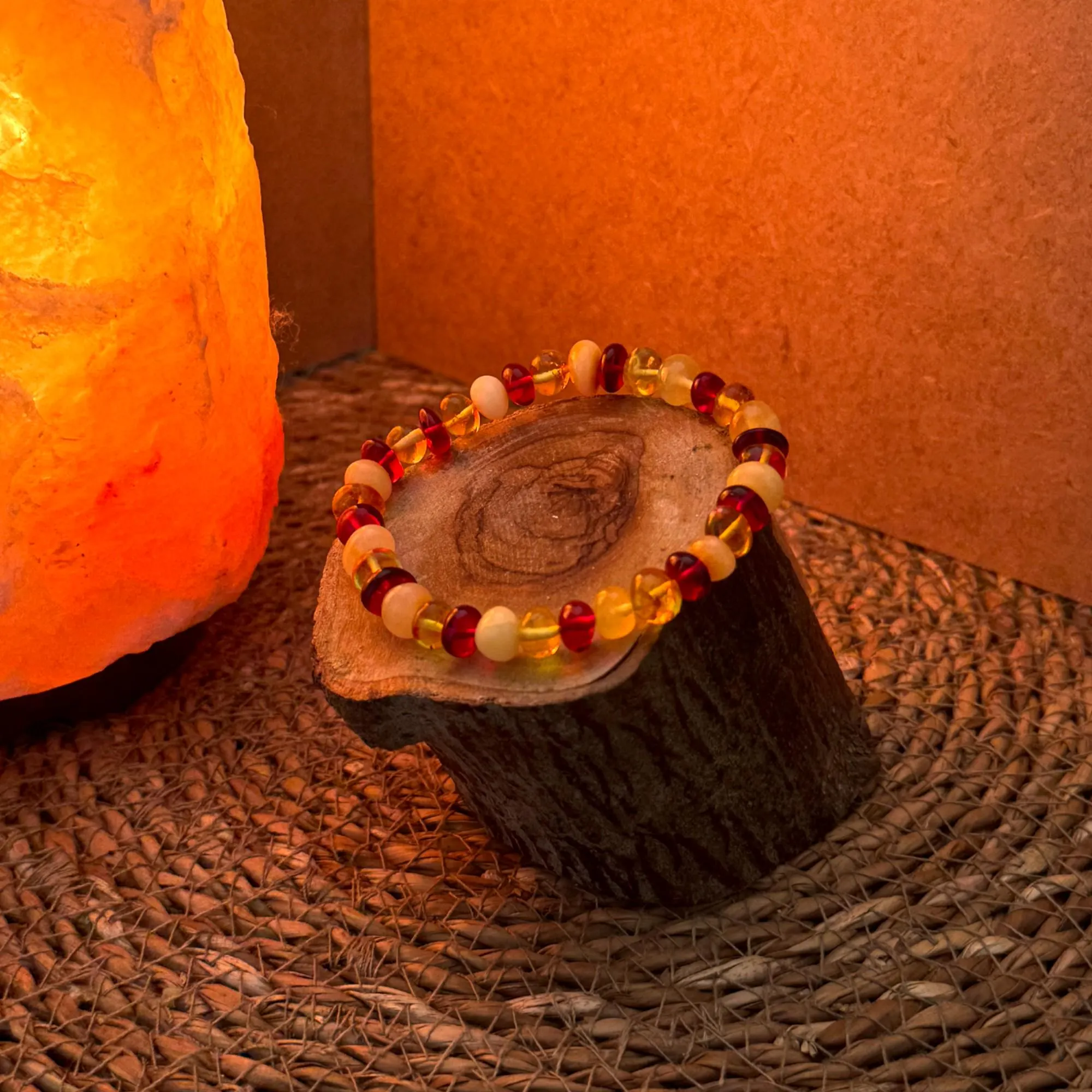 Rustic wood stand with warm ambient light showcasing the braceletβs glow. Ideal for artisan or handmade-style tags. Keywords: artisan amber bracelet, cozy jewelry setup, boho Baltic amber display.