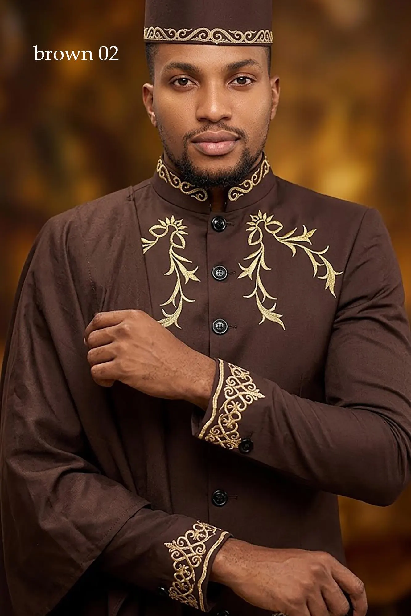 A man wearing a sophisticated burgundy 3-piece formal suit with intricate gold embroidery on the chest and cuffs, displayed in a professional setting