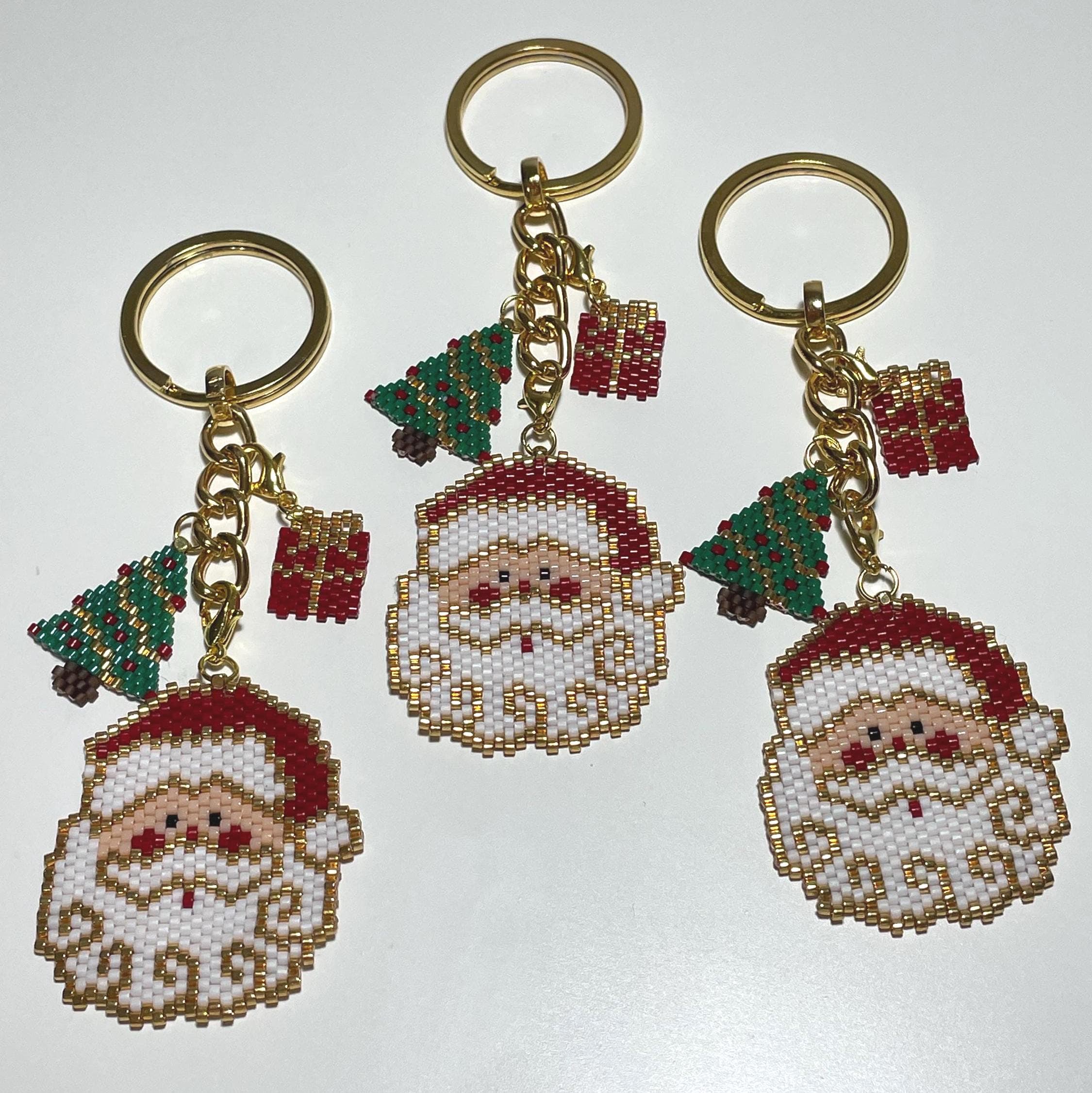 Bring holiday cheer wherever you go with this handmade beaded Christmas Santa & pine tree ornament! Perfect as a keychain, bag accessory, or meaningful gift for loved ones. The design features a Santa Claus, pine tree, and a matching mini gift ornament, all with festive red, green, gold, and white details.