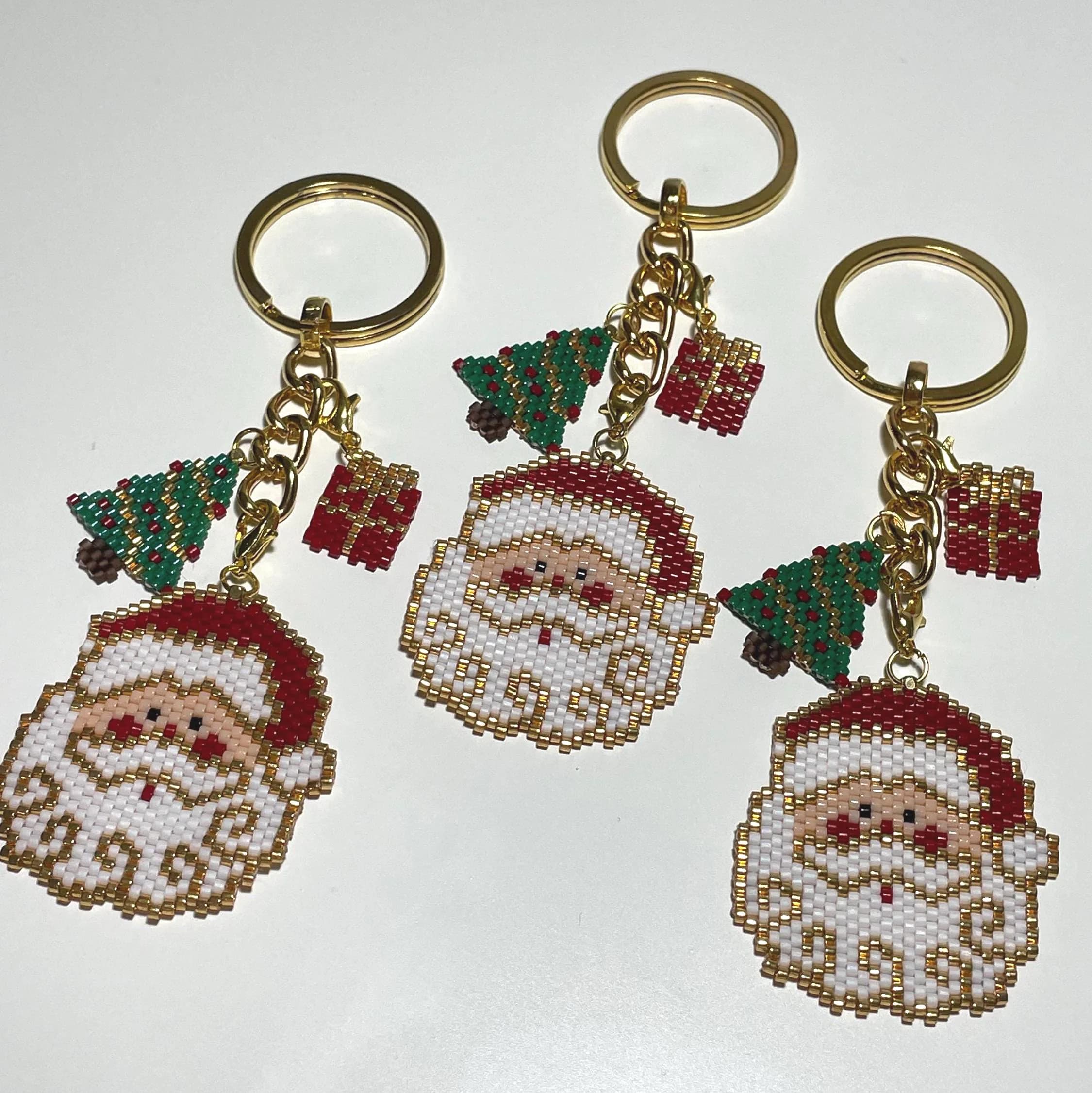 Bring holiday cheer wherever you go with this handmade beaded Christmas Santa & pine tree ornament! Perfect as a keychain, bag accessory, or meaningful gift for loved ones. The design features a Santa Claus, pine tree, and a matching mini gift ornament, all with festive red, green, gold, and white details.