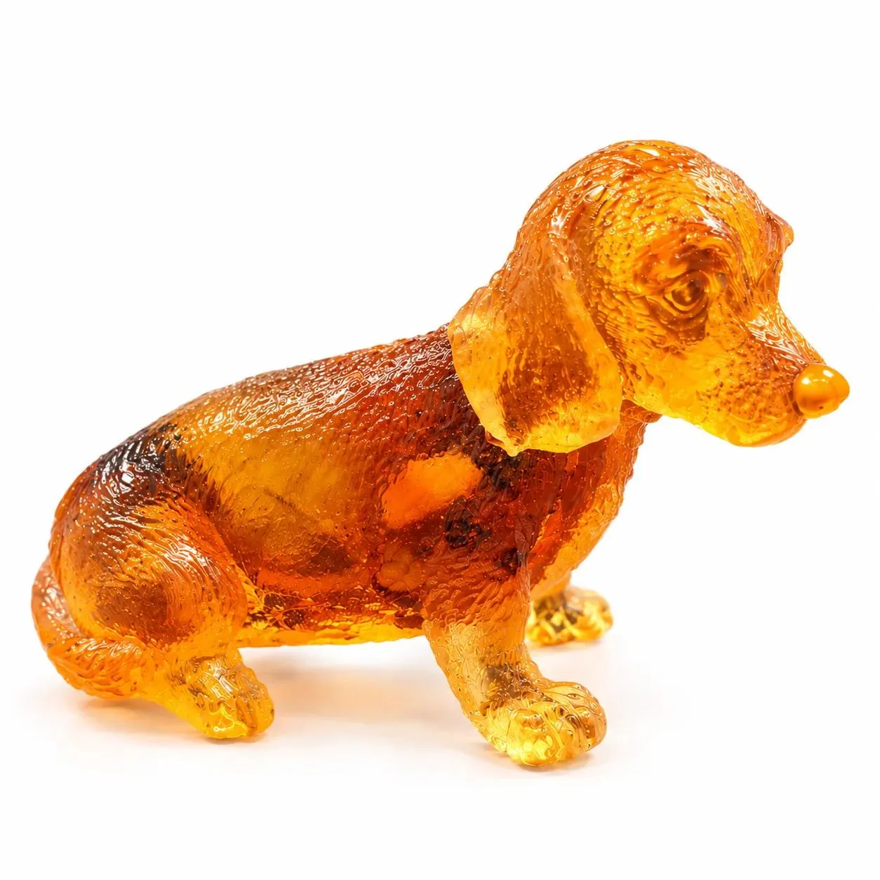 Made in USA natural Baltic amber sitting Dachshund figurine on white background — translucent honey-cognac wiener dog with natural inclusions, KIZIMA® Brooklyn NY