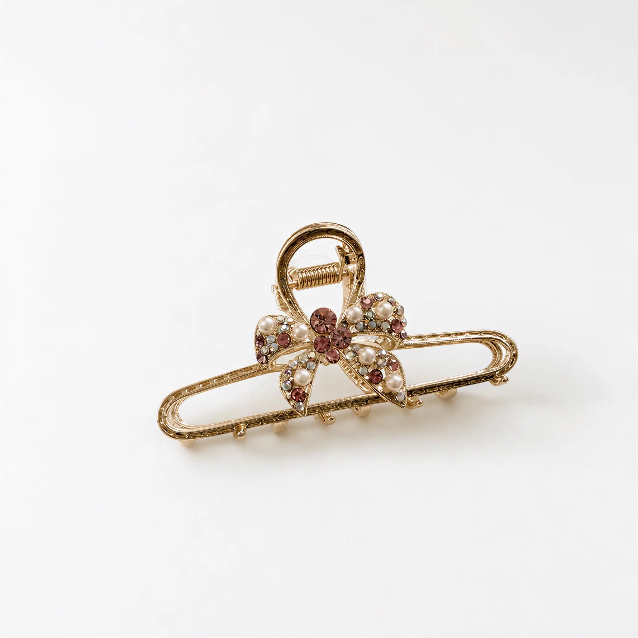 A gold-colored hair clip adorned with a flower-shaped design and embellished with gemstones.
