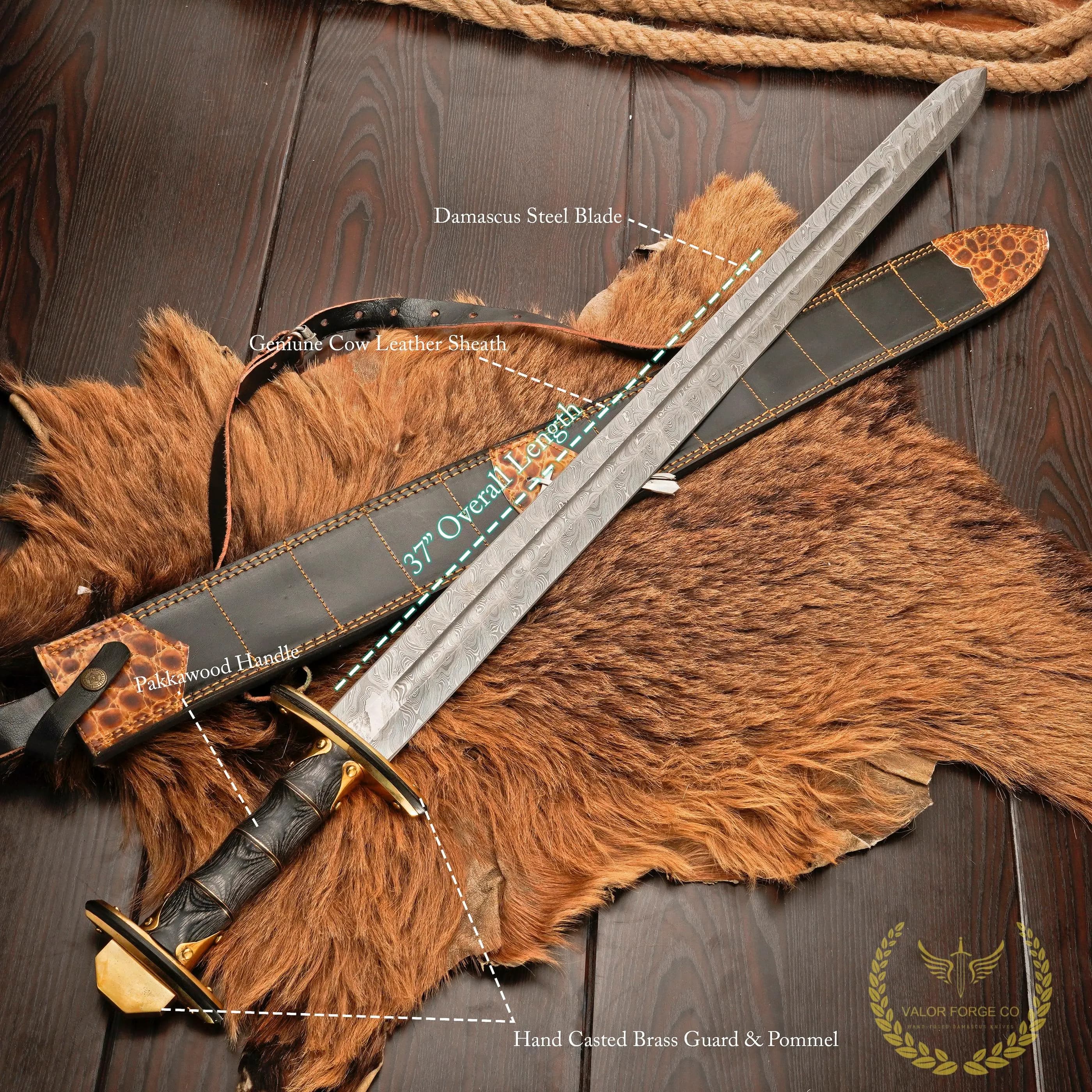 Full-length sword with a black grip, gold-colored guard and damascus patterned blade lying diagonally on orange fur, with part of the black scabbard visible at the left.