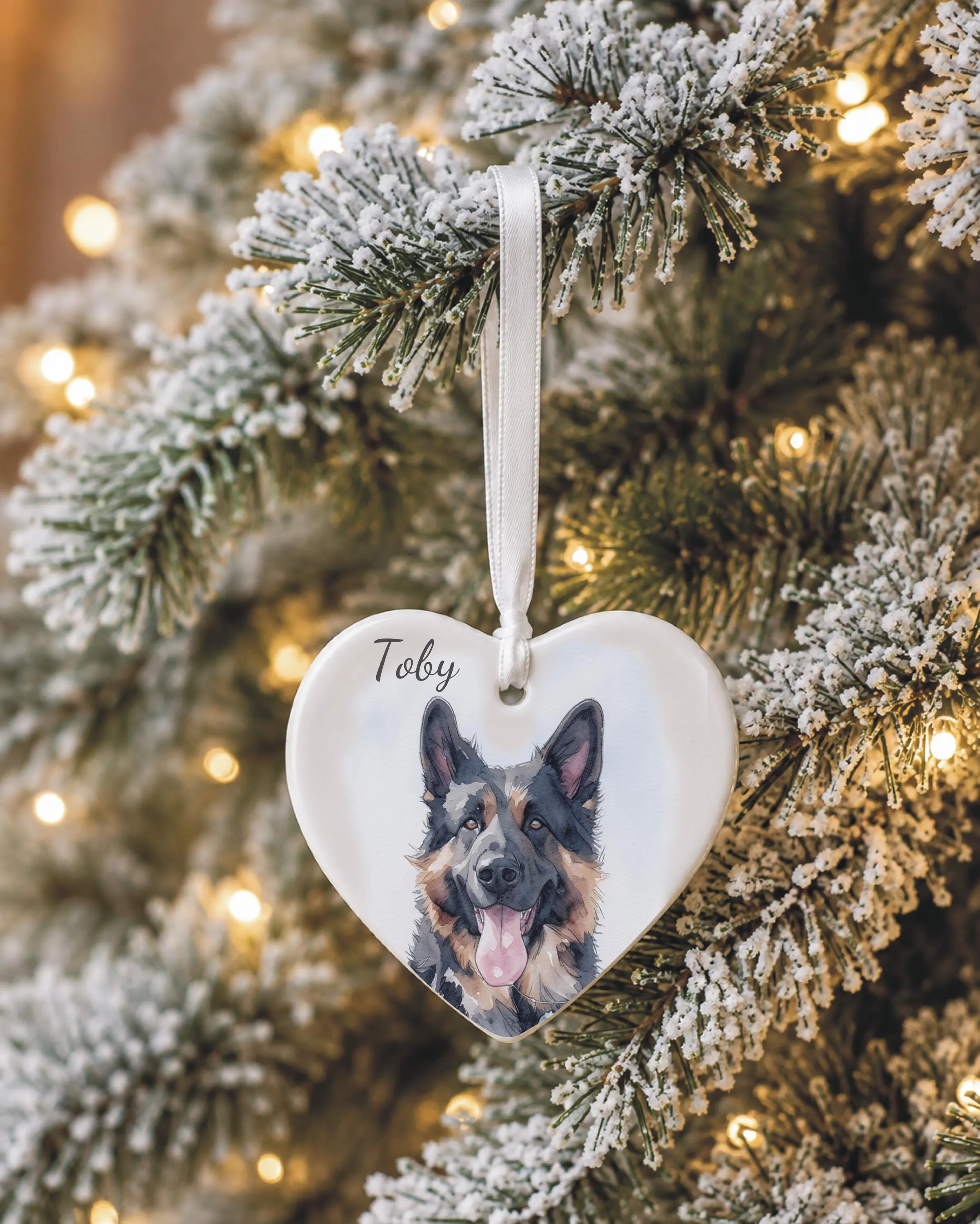 Personalised dog ceramic heart ornament hanging on a Christmas tree, featuring a unique watercolour-style pet illustration and dog's name, making a special Christmas keepsake.